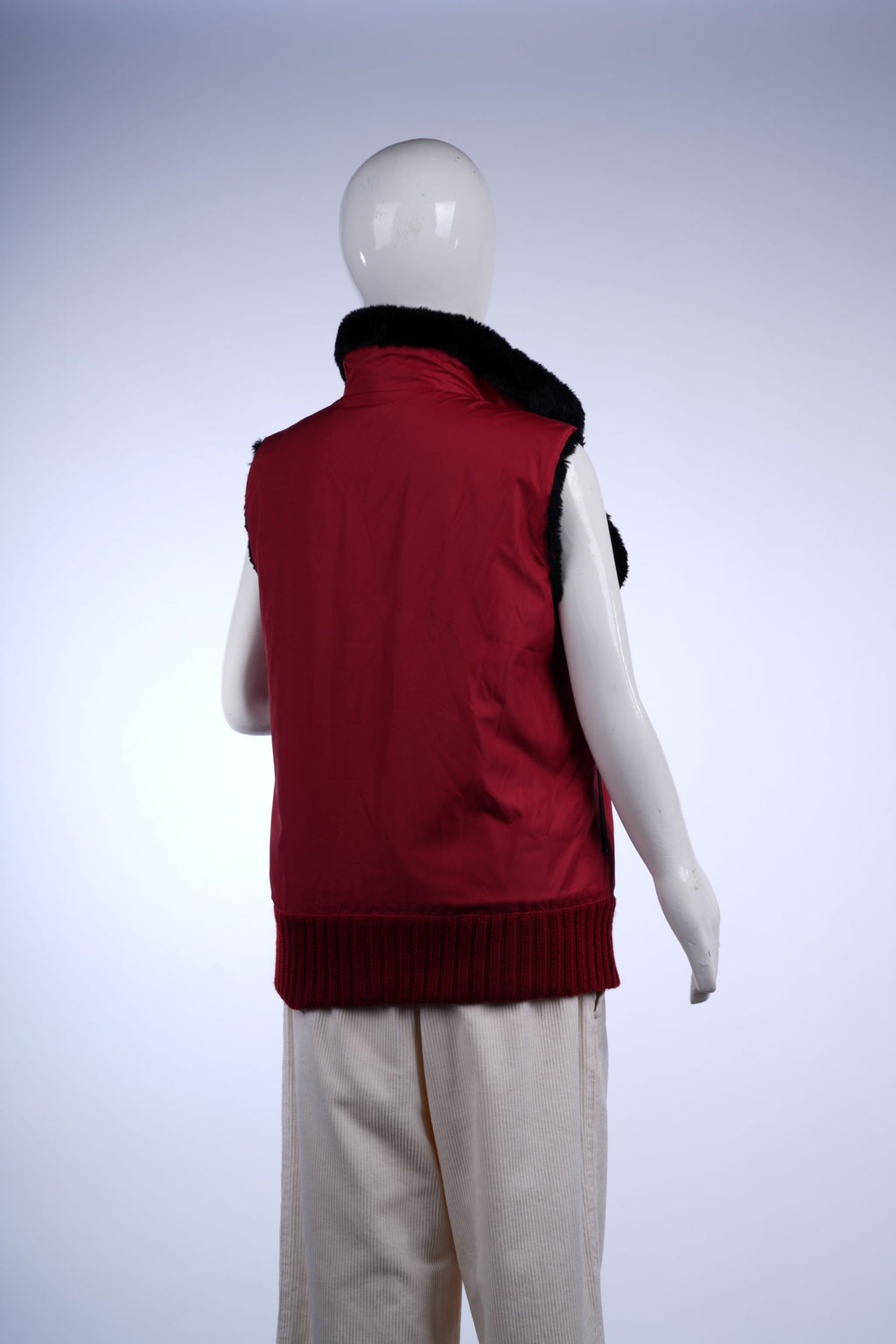 Red sleeveless outerwear with zip closure and faux fur collar for a cozy, fashionable look.