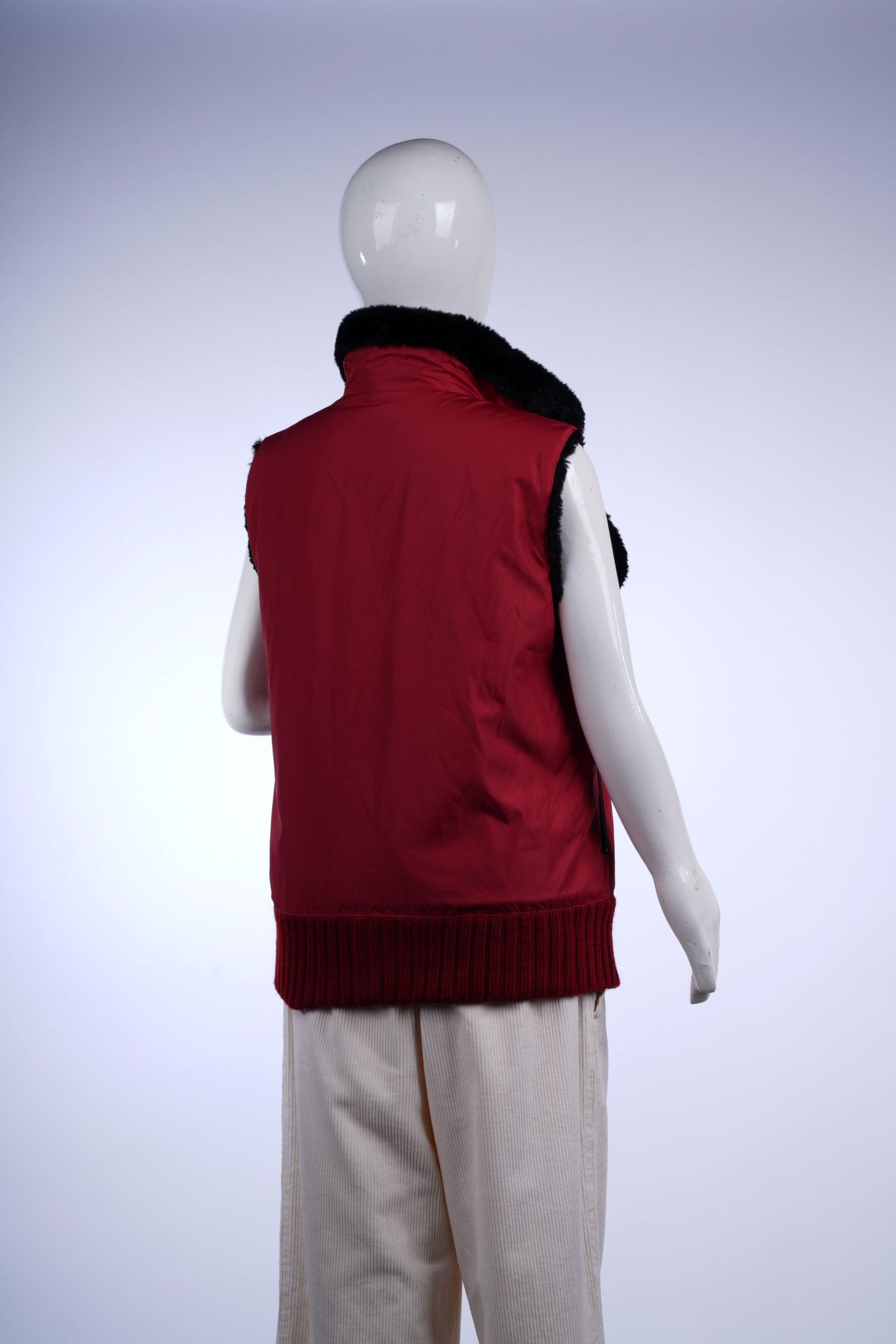 Red sleeveless outerwear with zip closure and faux fur collar for a cozy, fashionable look.