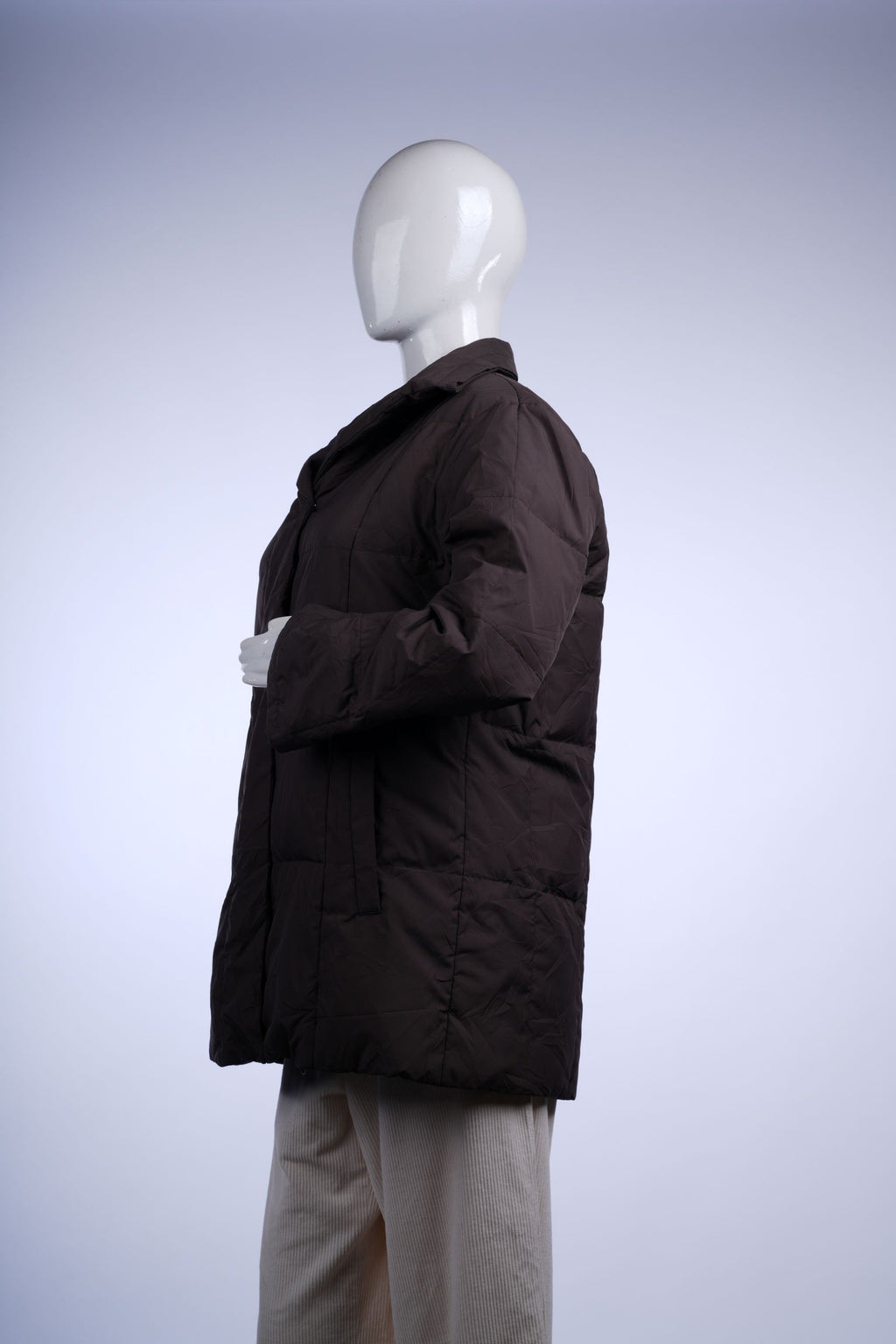 Warm and stylish brown quilted jacket with zip and button closure, perfect for cold-weather layering.