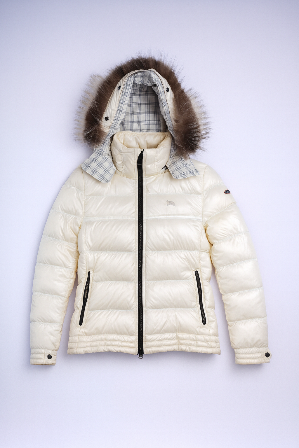 Black Burberry puffer jacket with fur-trimmed hood and iconic Nova Check lining, designed for warmth and luxury.