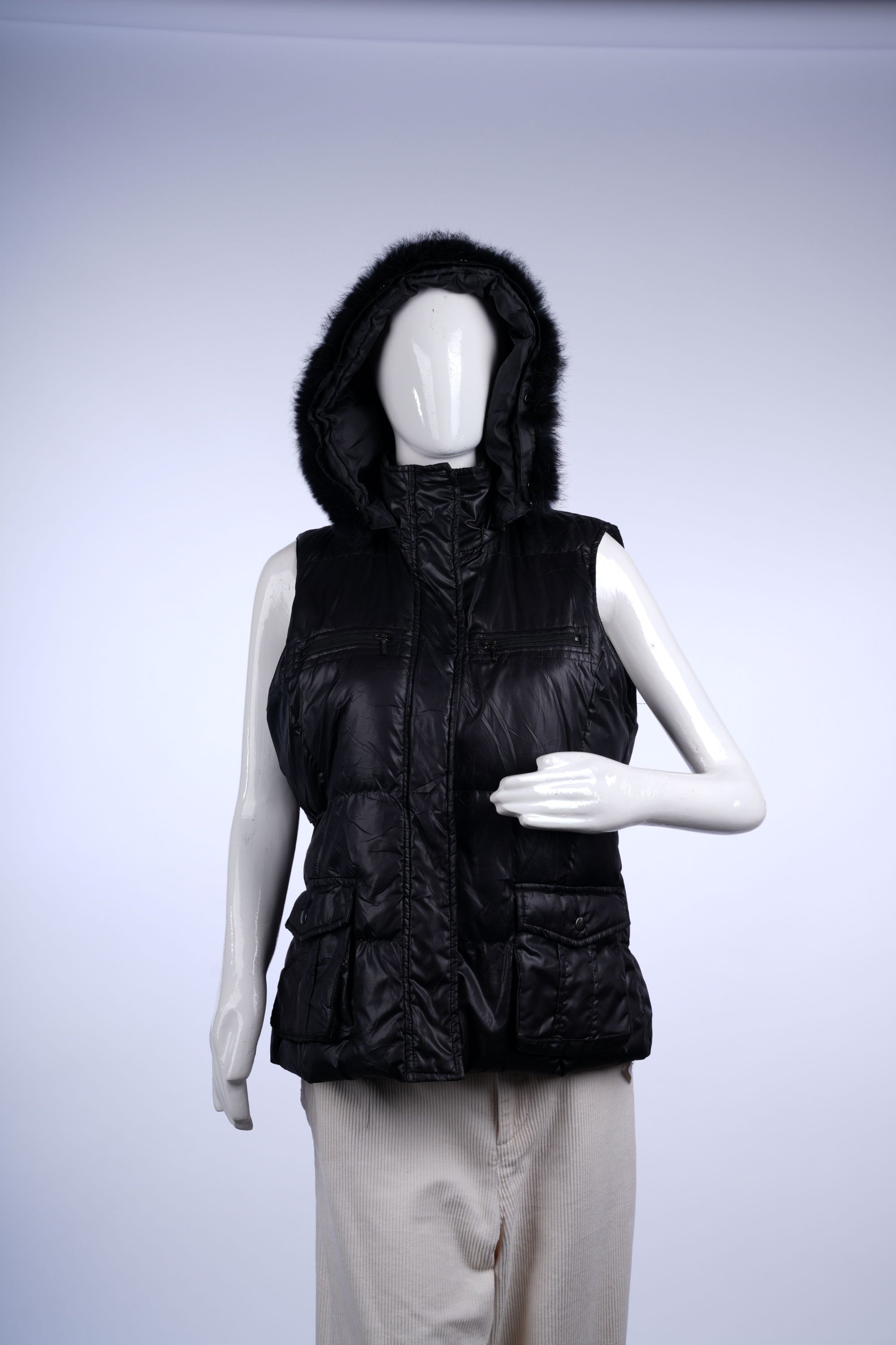 Warm black puffer vest featuring fur detailing, practical pockets, and secure zip closure.