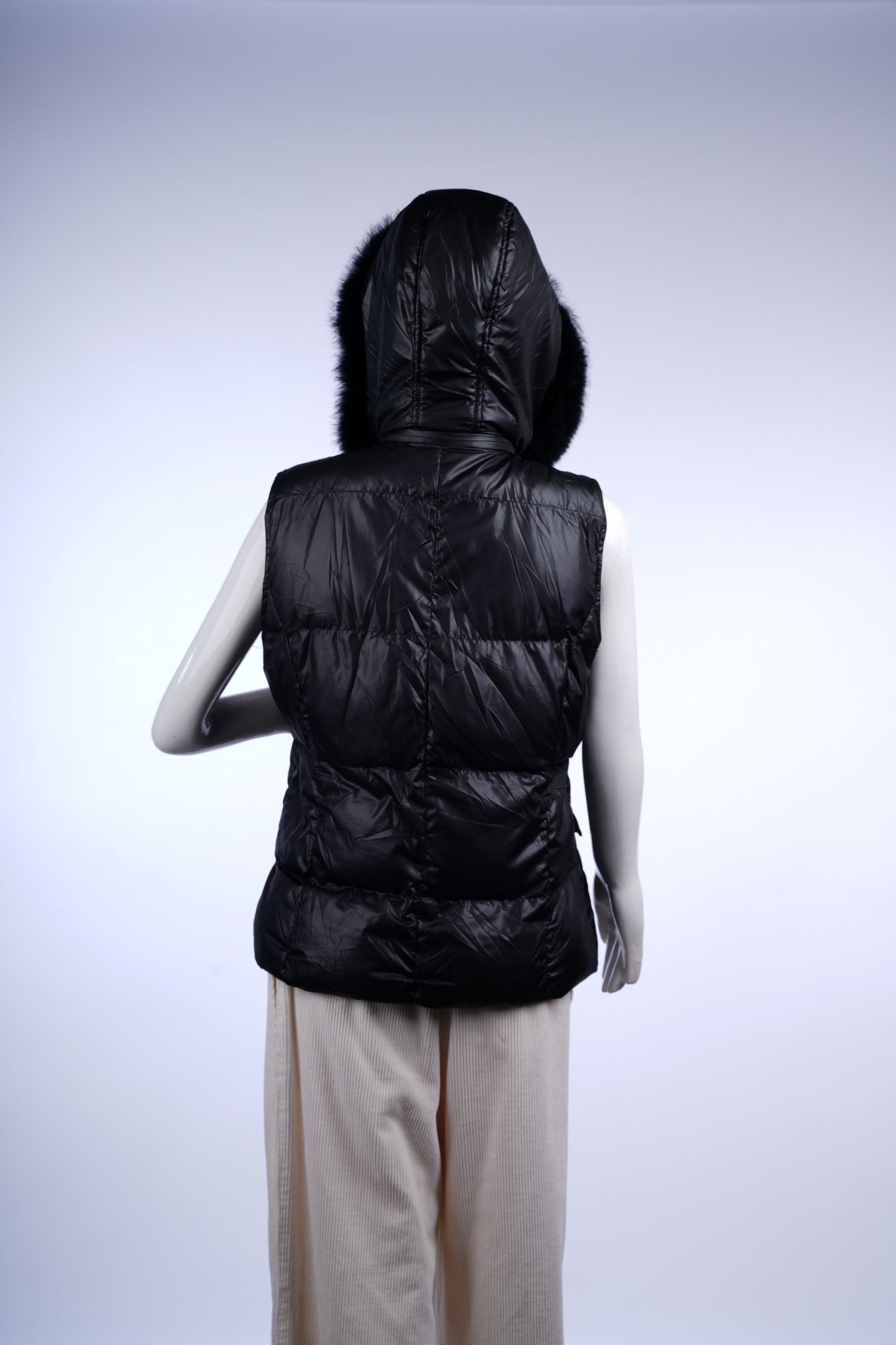 Stylish black puffer vest with cozy fur trim, multiple functional pockets, and zip-front fastening.