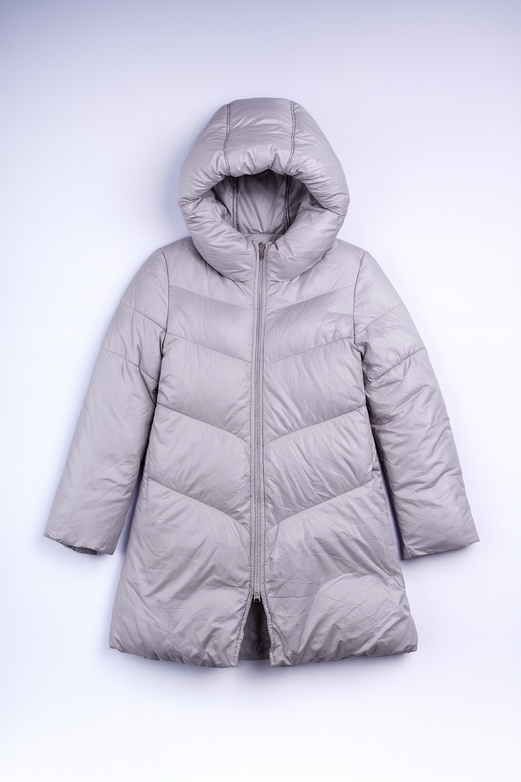 Light grey long puffer coat with stand-up collar and full-length zipper, quilted and insulated for winter warmth.