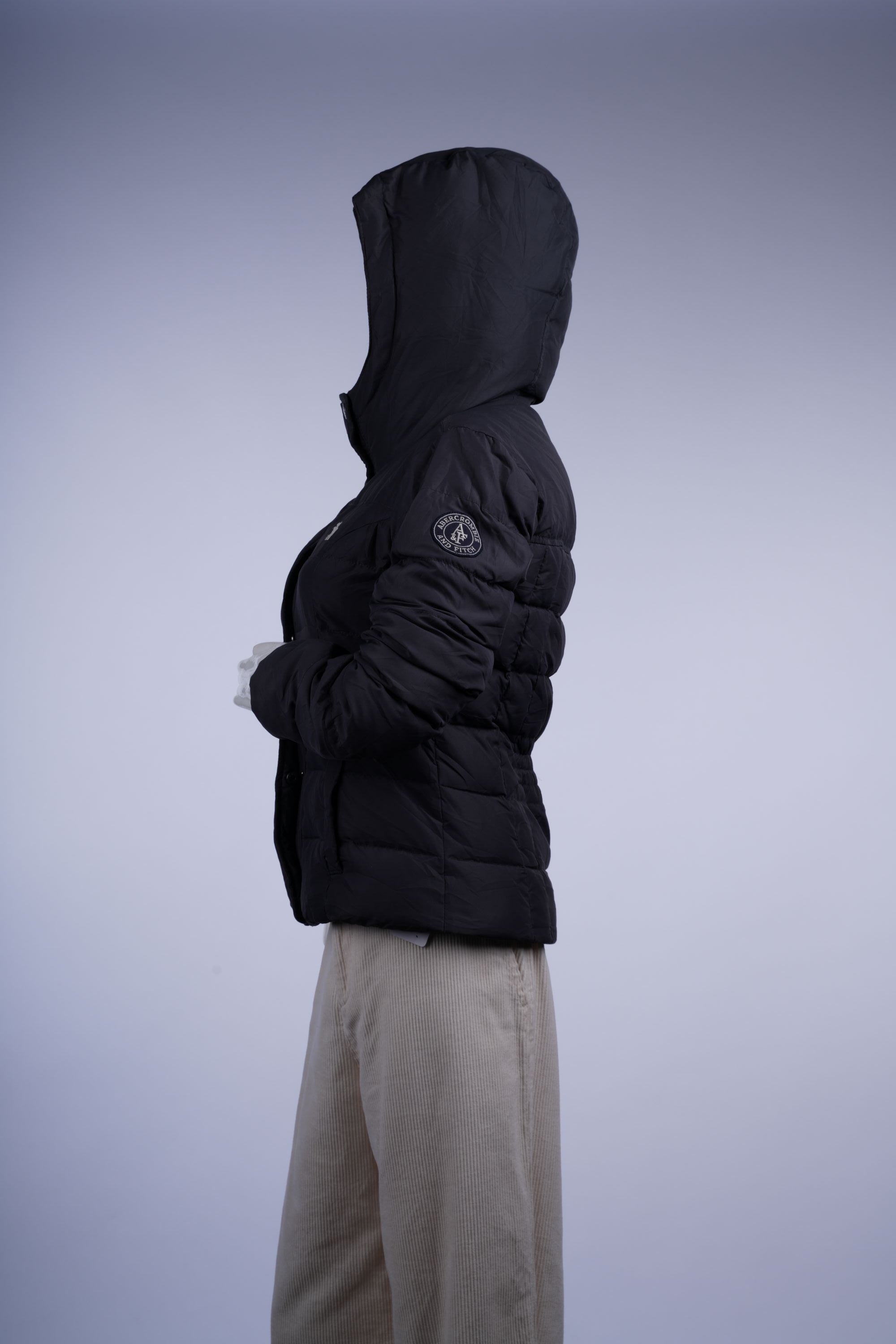 Insulated dark grey/black jacket featuring quilted construction, stand-up collar, and full-length zipper for winter warmth.