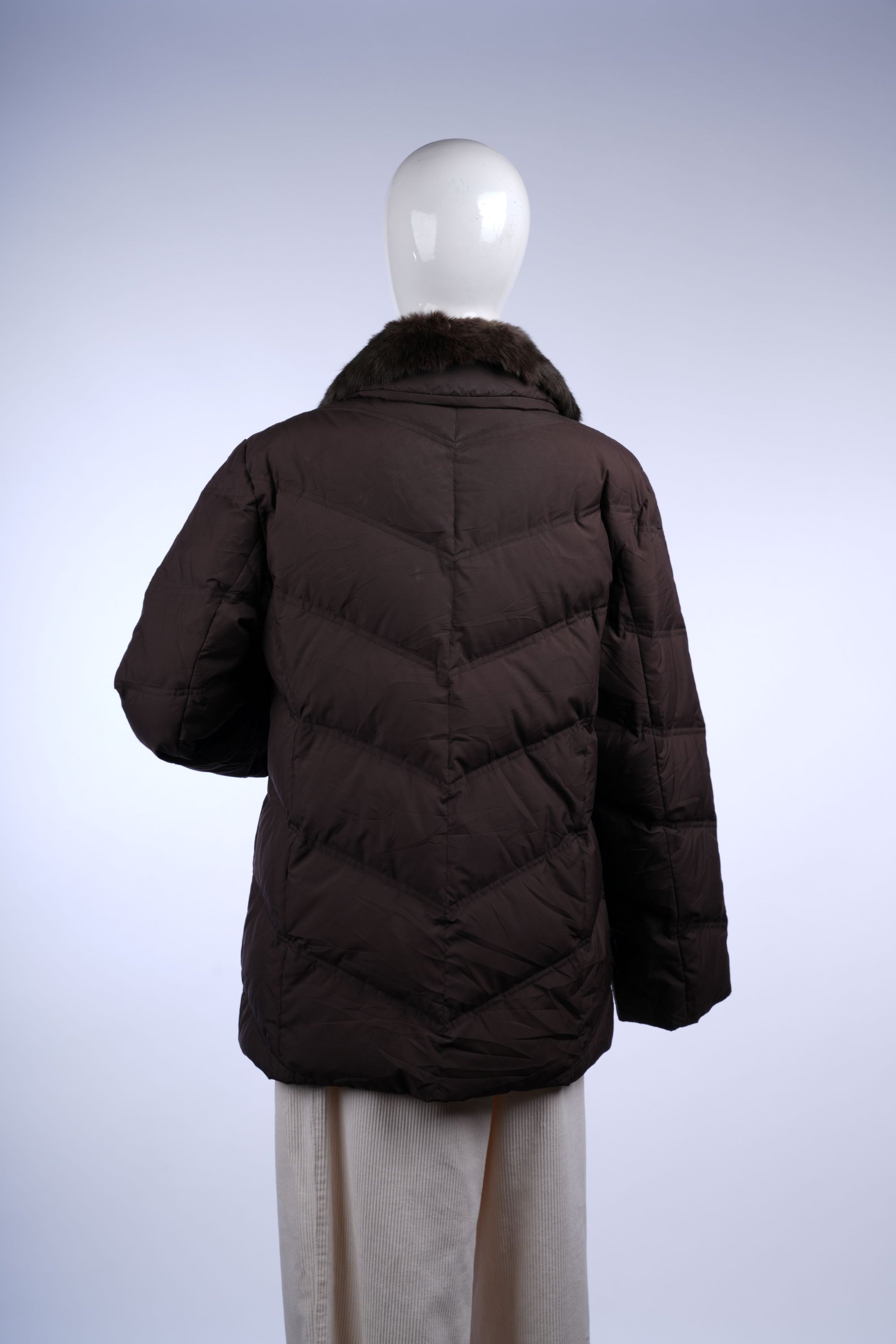 Elegant brown puffer jacket with plush faux fur trim and quilted insulation, combining style and winter functionality.