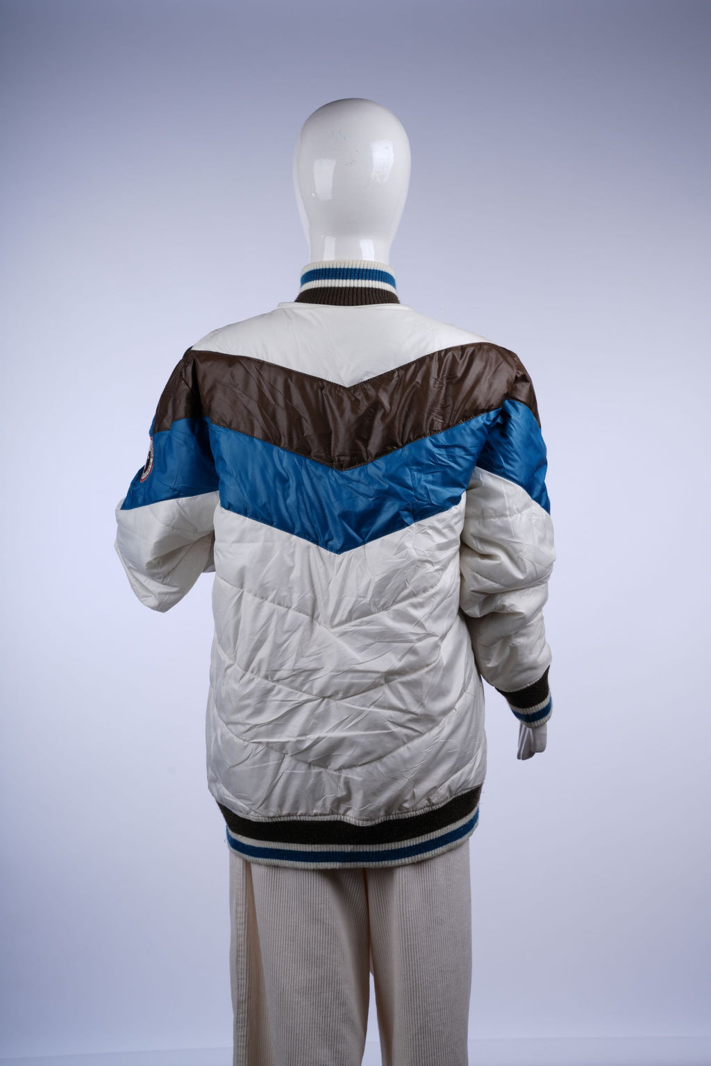 Stylish white puffer jacket with teal and dark brown stripes, ribbed cuffs and hem, designed for retro-inspired casual or outdoor looks.