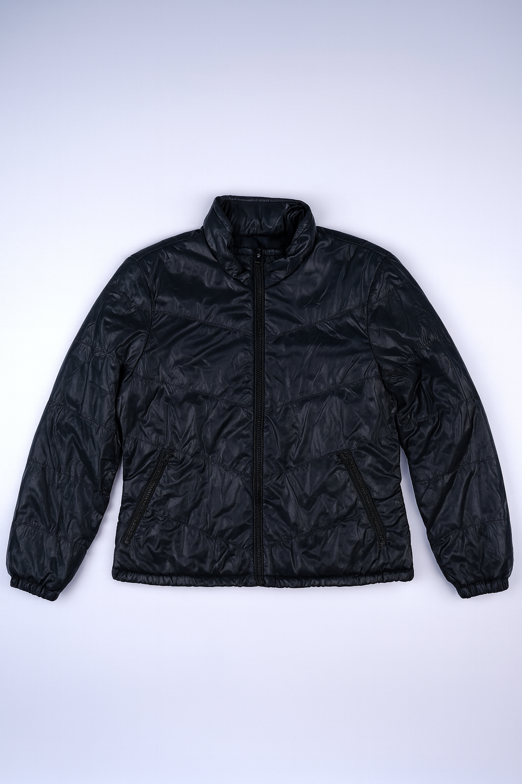 Black quilted puffer jacket with stand-up collar and zippered pockets, lightweight and insulated for everyday warmth.