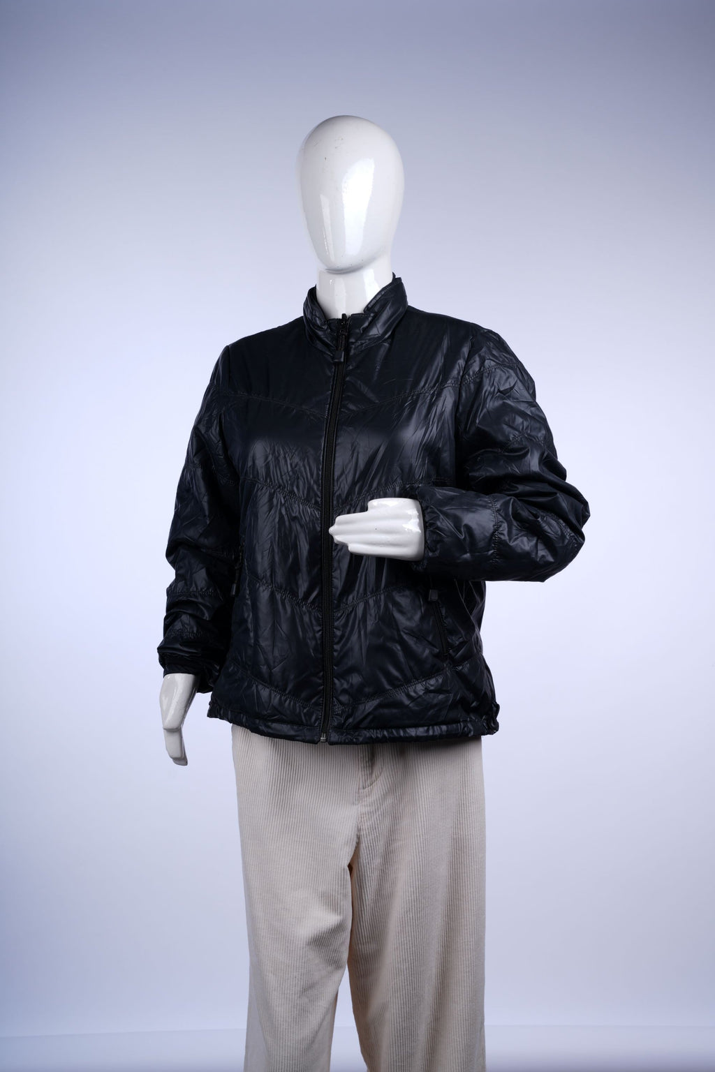 Stylish black quilted jacket featuring a high collar, zip pockets, and lightweight insulation for cold-weather comfort.
