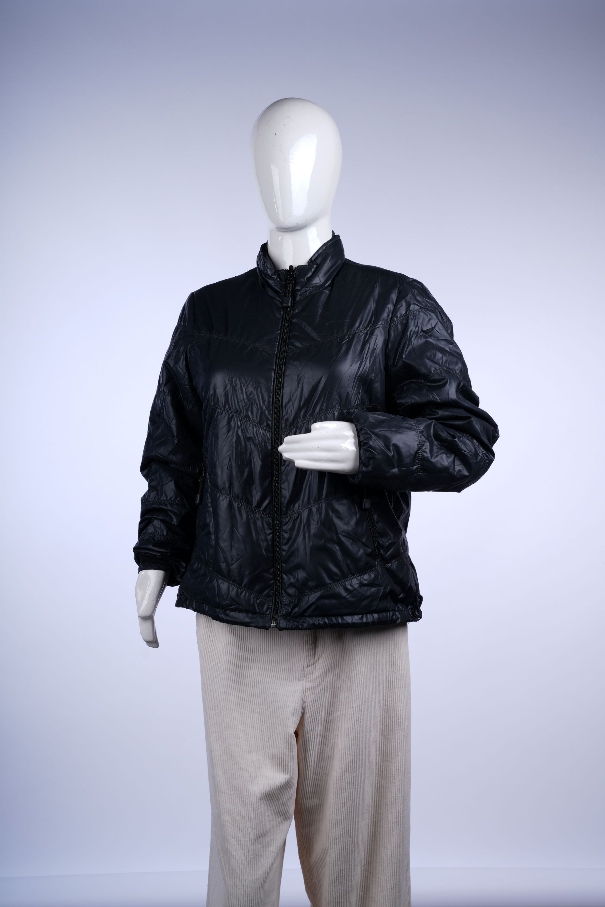 Stylish black quilted jacket featuring a high collar, zip pockets, and lightweight insulation for cold-weather comfort.
