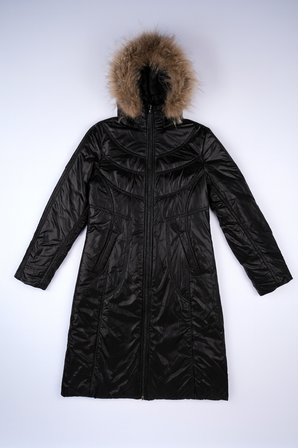 Shiny black long-line puffer jacket with quilted insulation and fur-lined hood for stylish winter warmth.