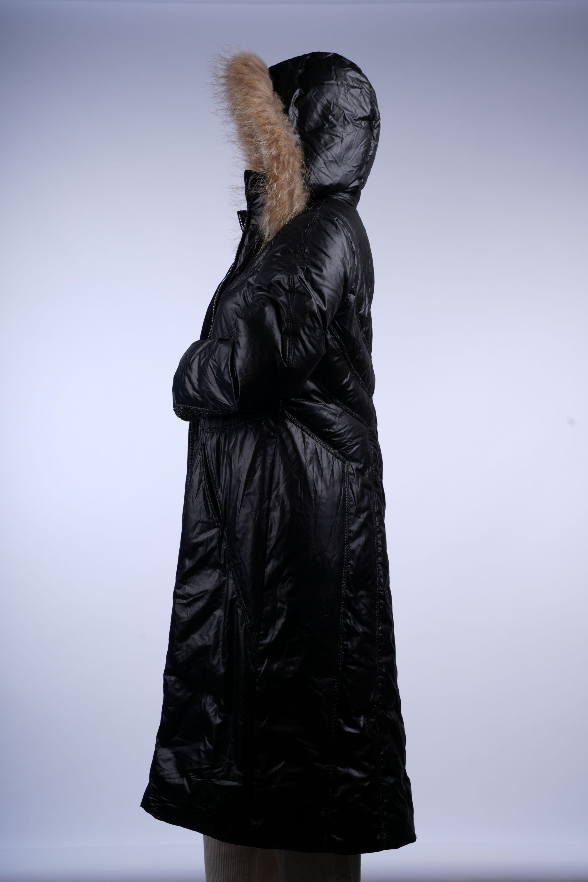 Long black puffer jacket with glossy finish, insulated quilting, and cozy fur-lined hood.