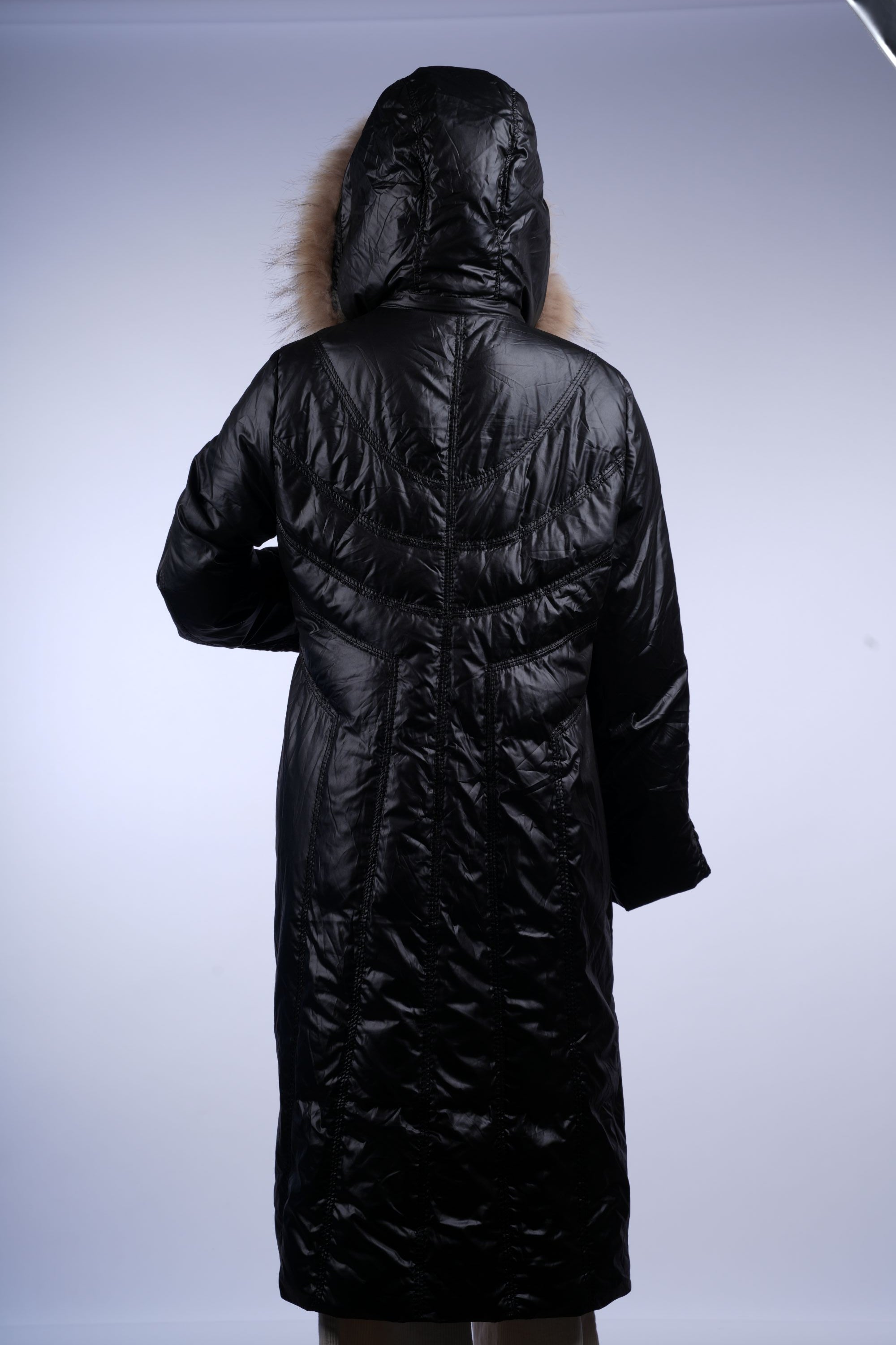 Fashionable black winter coat with full-length quilted design and fur-trimmed hood for warmth and style.
