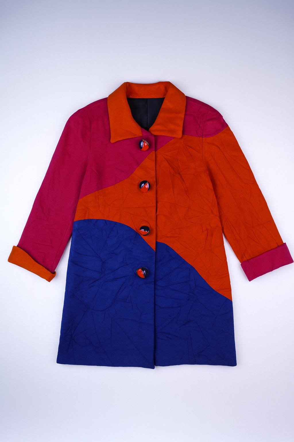 Vintage color-block coat in bold pink, orange, and royal blue with collared neckline and contrasting buttons, featuring a retro 80s?90s style.