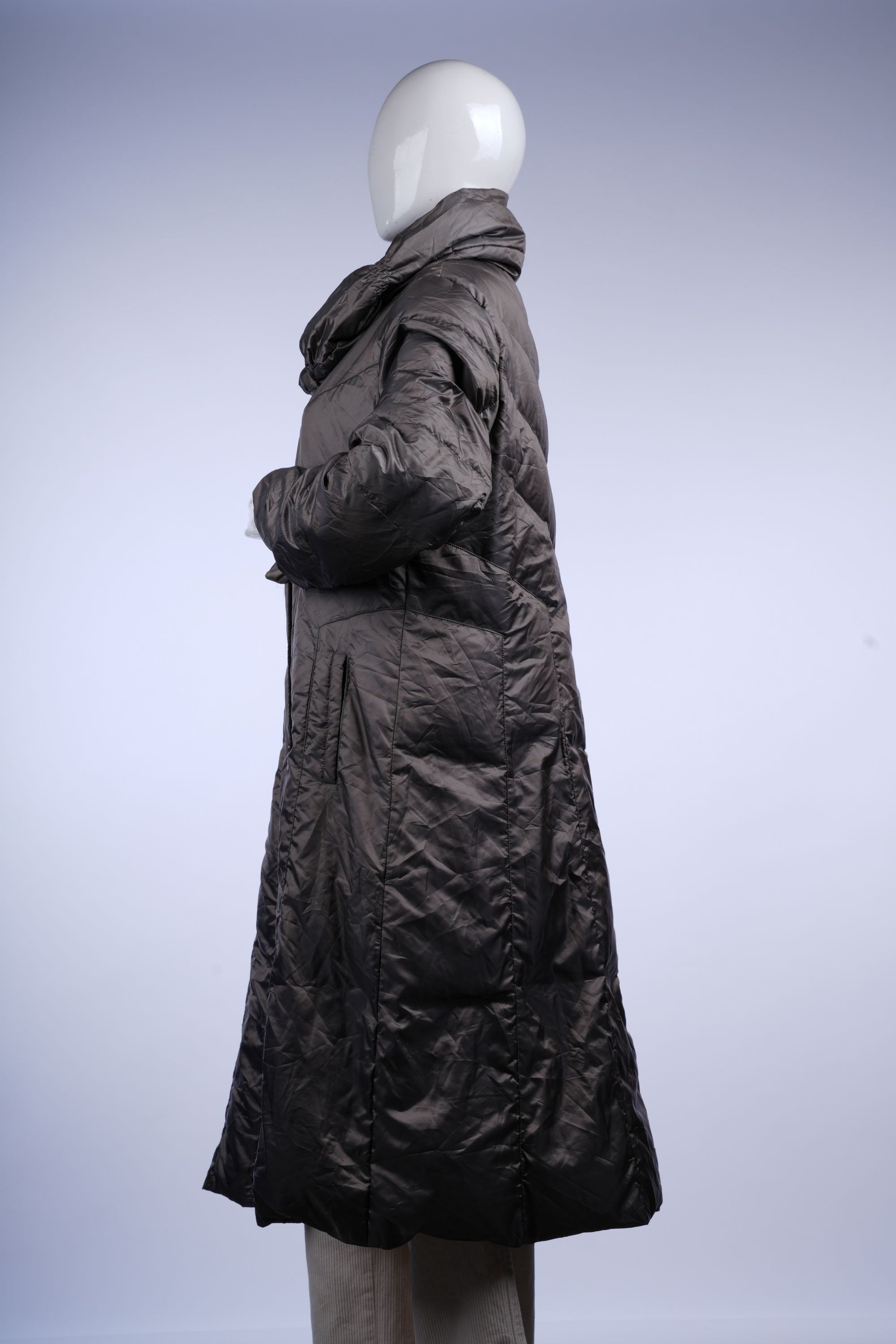 Warm and modern long grey puffer coat featuring quilted panels, high collar, and zip closure for winter-ready style.