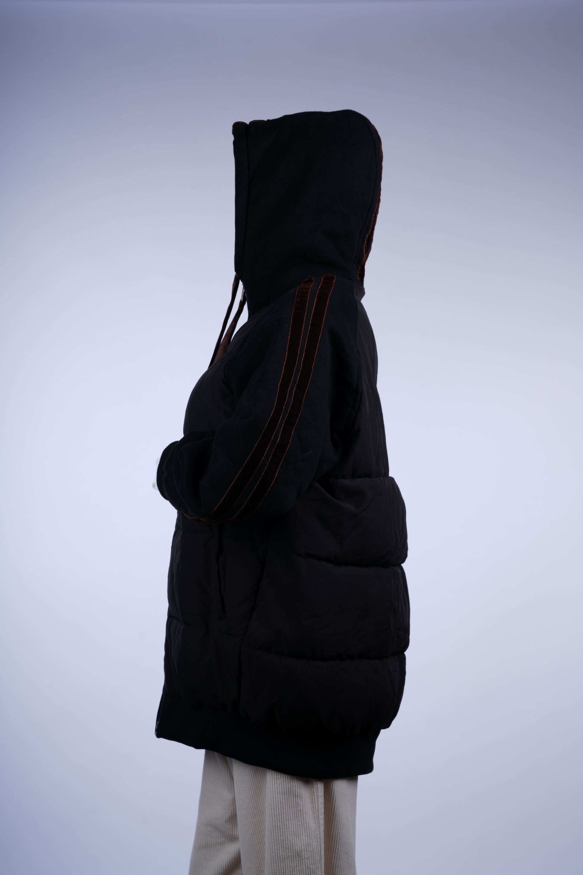Warm black hooded puffer jacket with zip closure and side pockets, designed for everyday winter comfort.