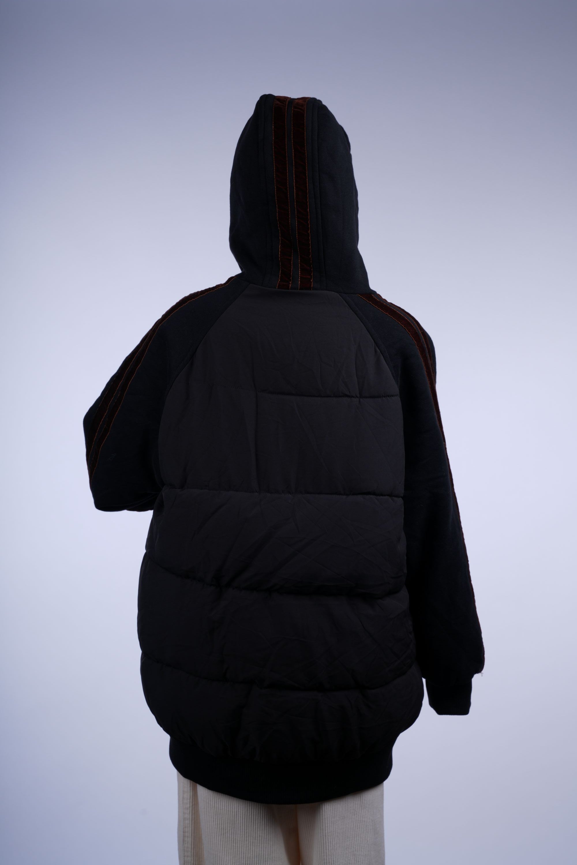 Casual black puffer coat featuring hood, full-length zipper, and quilted insulation for even warmth.