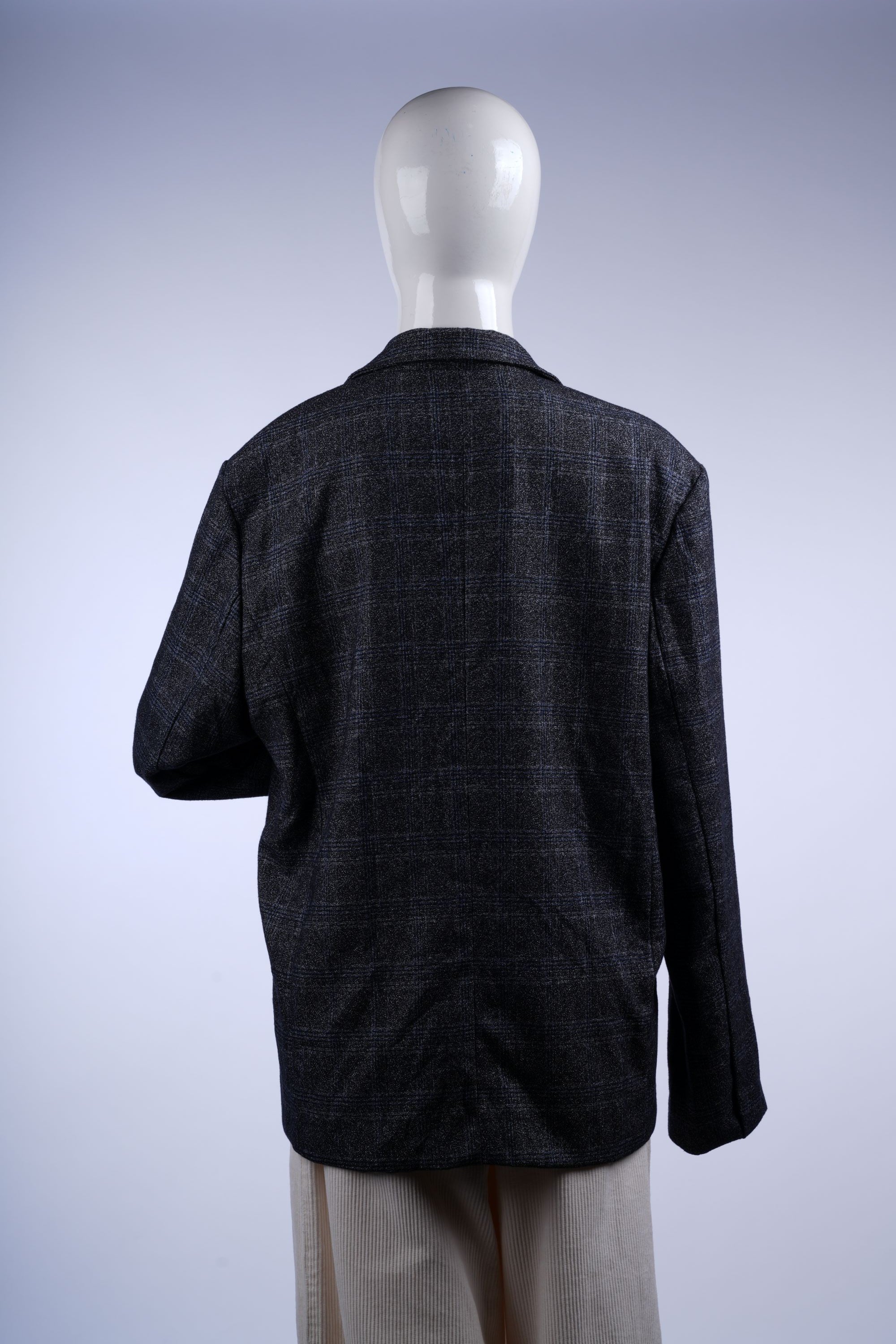 Elegant grey plaid blazer with structured fit, flap pockets, notched lapels, and a colorful purple lining for contrast.