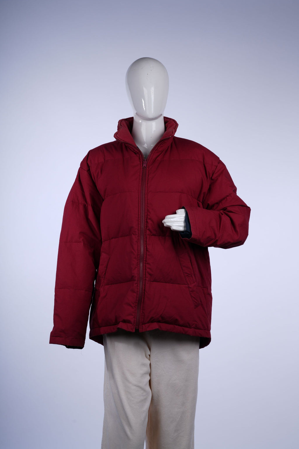 Warm red puffer jacket featuring quilted design, plaid lining, stand-up collar, zip closure, and front pockets.