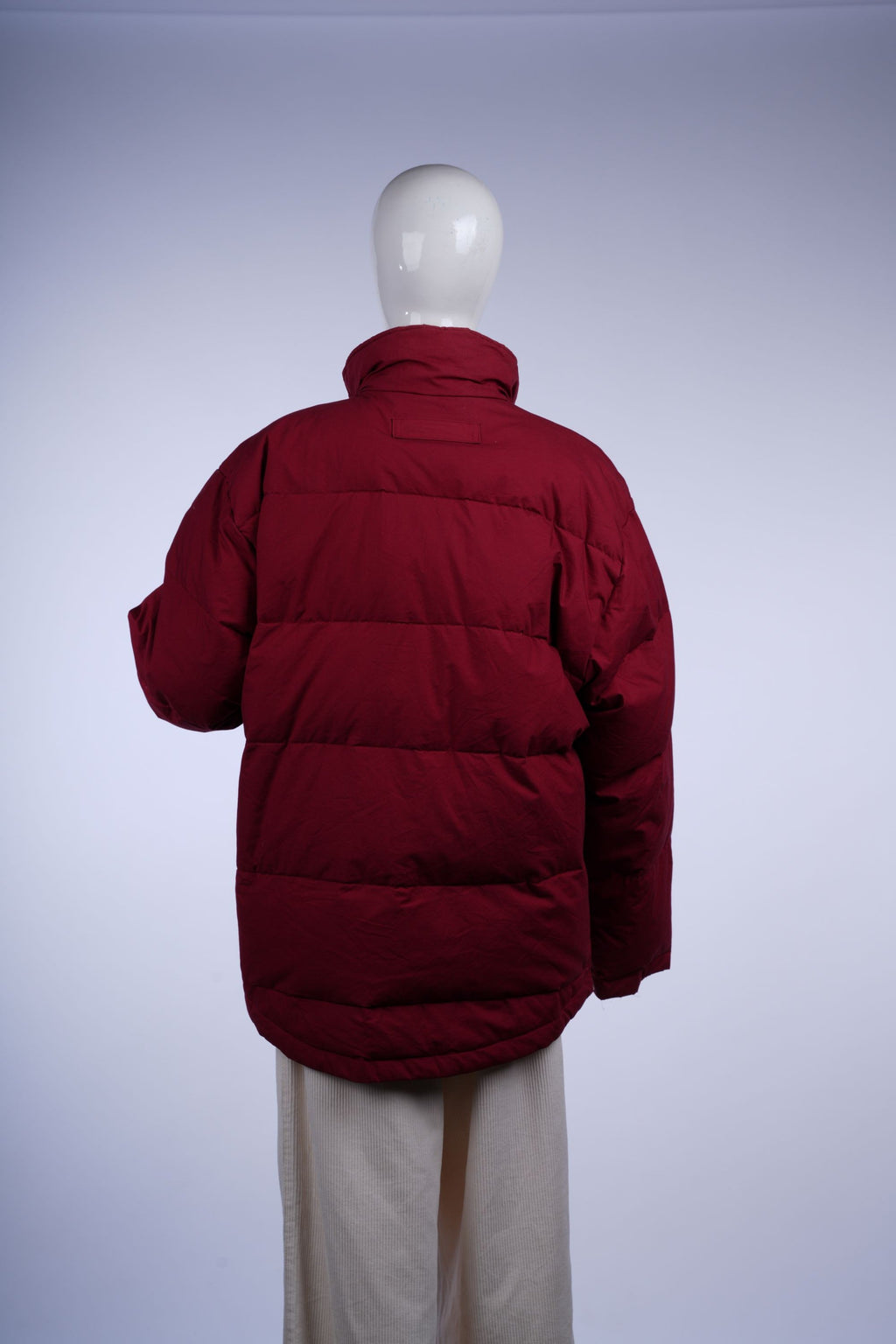 Insulated red puffer jacket with quilted pattern, plaid lining, zip closure, stand-up collar, and functional pockets.