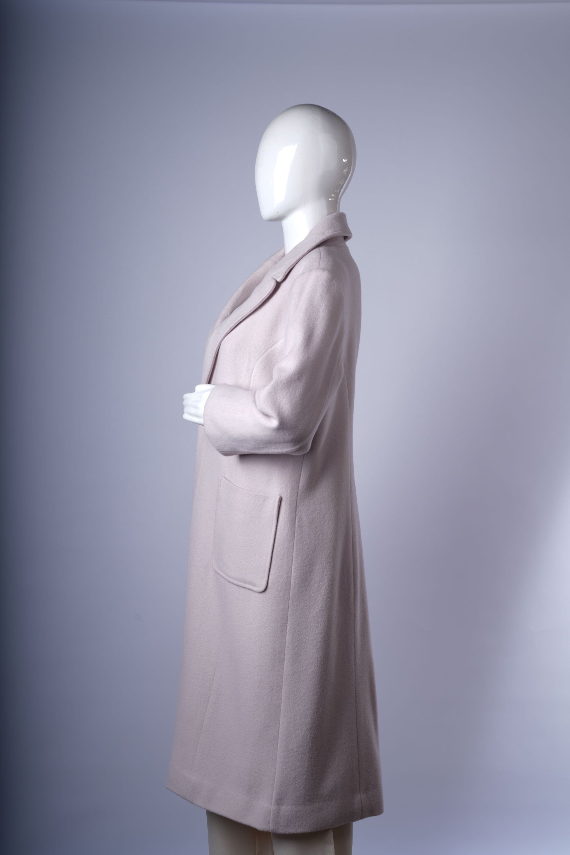 Chic pale neutral coat with double-breasted design, notched lapels, and mid-length silhouette, perfect for polished layering.