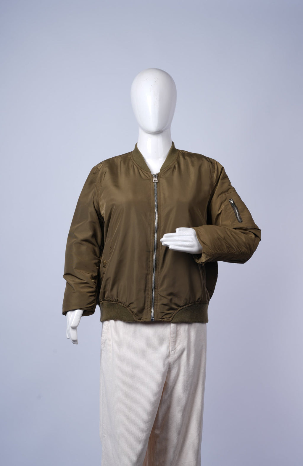 Casual women's olive green puffer jacket with bomber design and functional pockets.