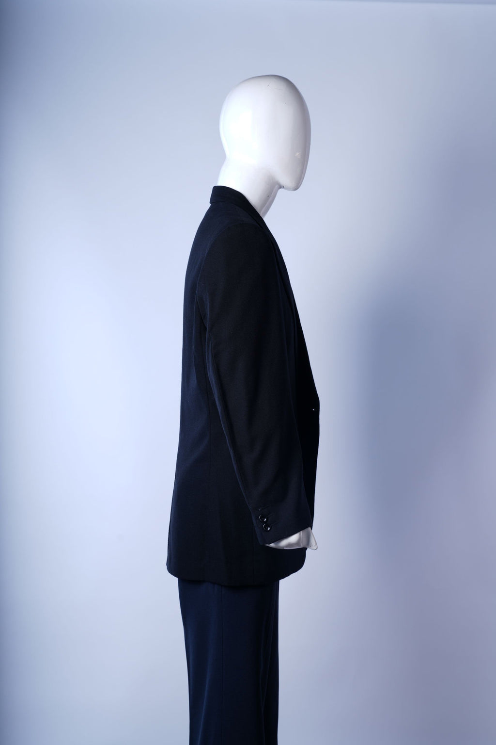 Elegant black suit blazer with flap pockets and precise tailoring for formal occasions.
