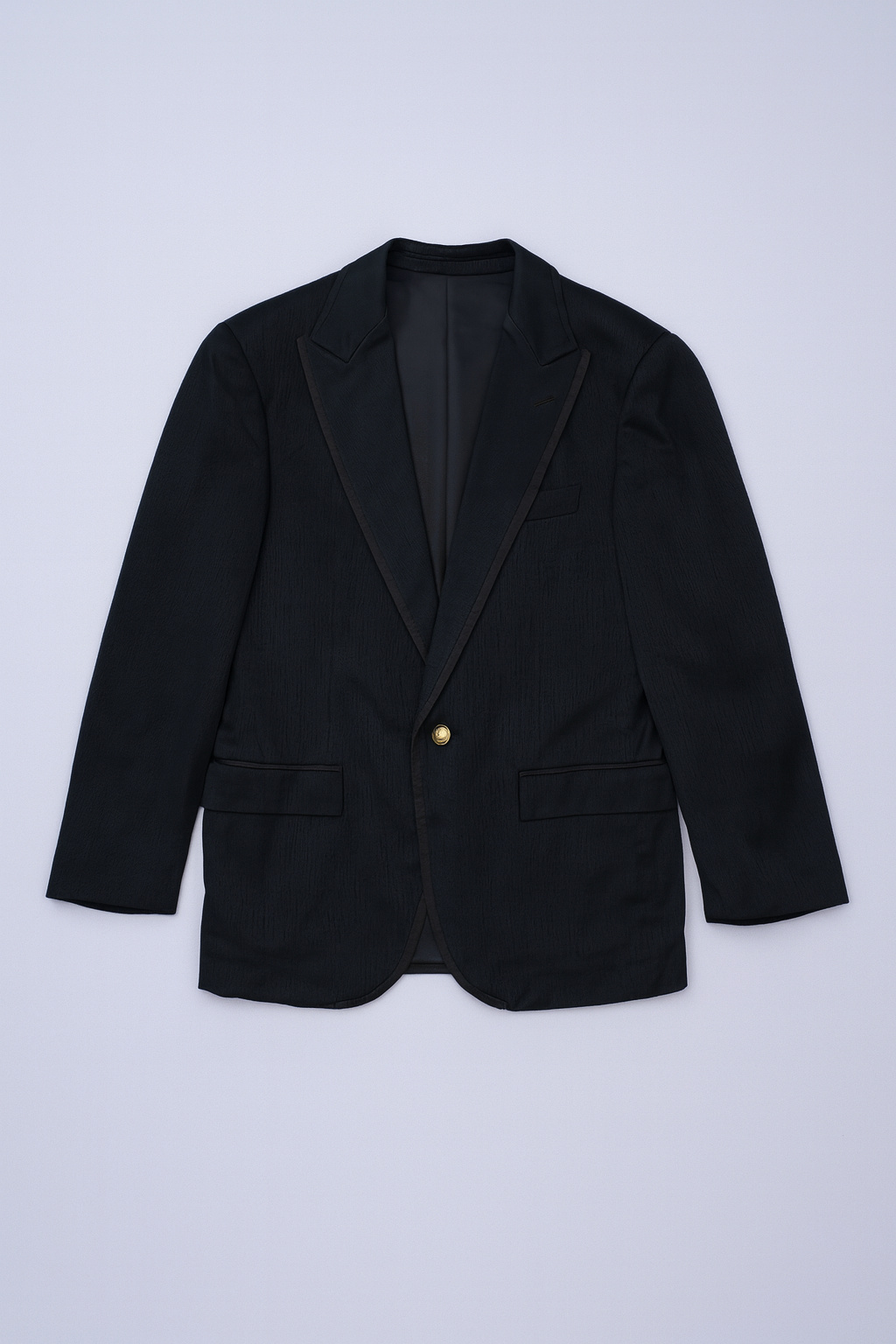 Dark formal blazer with flap pockets, notched lapels, and tailored fit for men.
