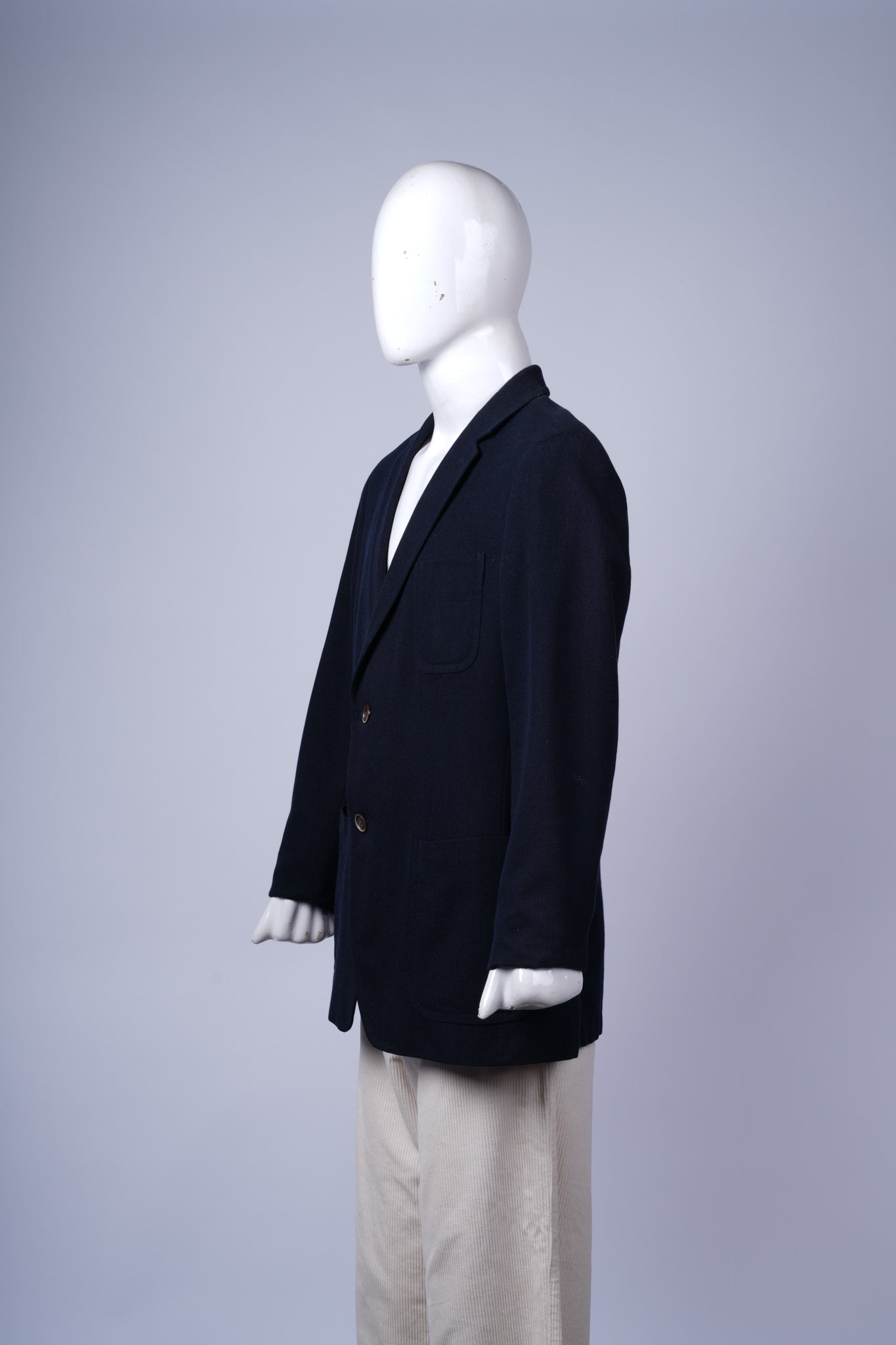 Elegant dark blazer featuring classic flap pockets and tailored notched lapels.