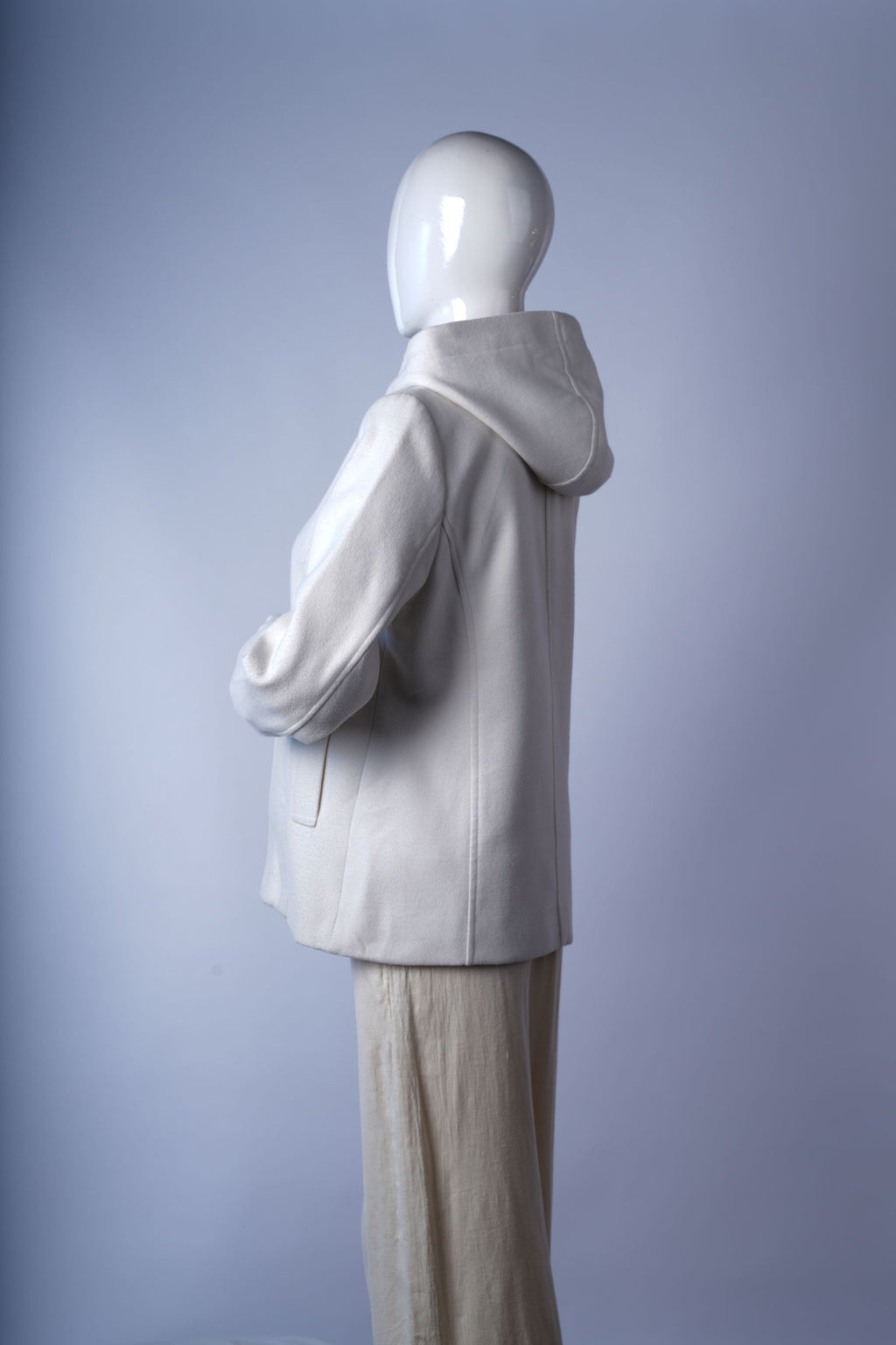 Soft wool-blend longline coat in ivory with sophisticated tailored details.