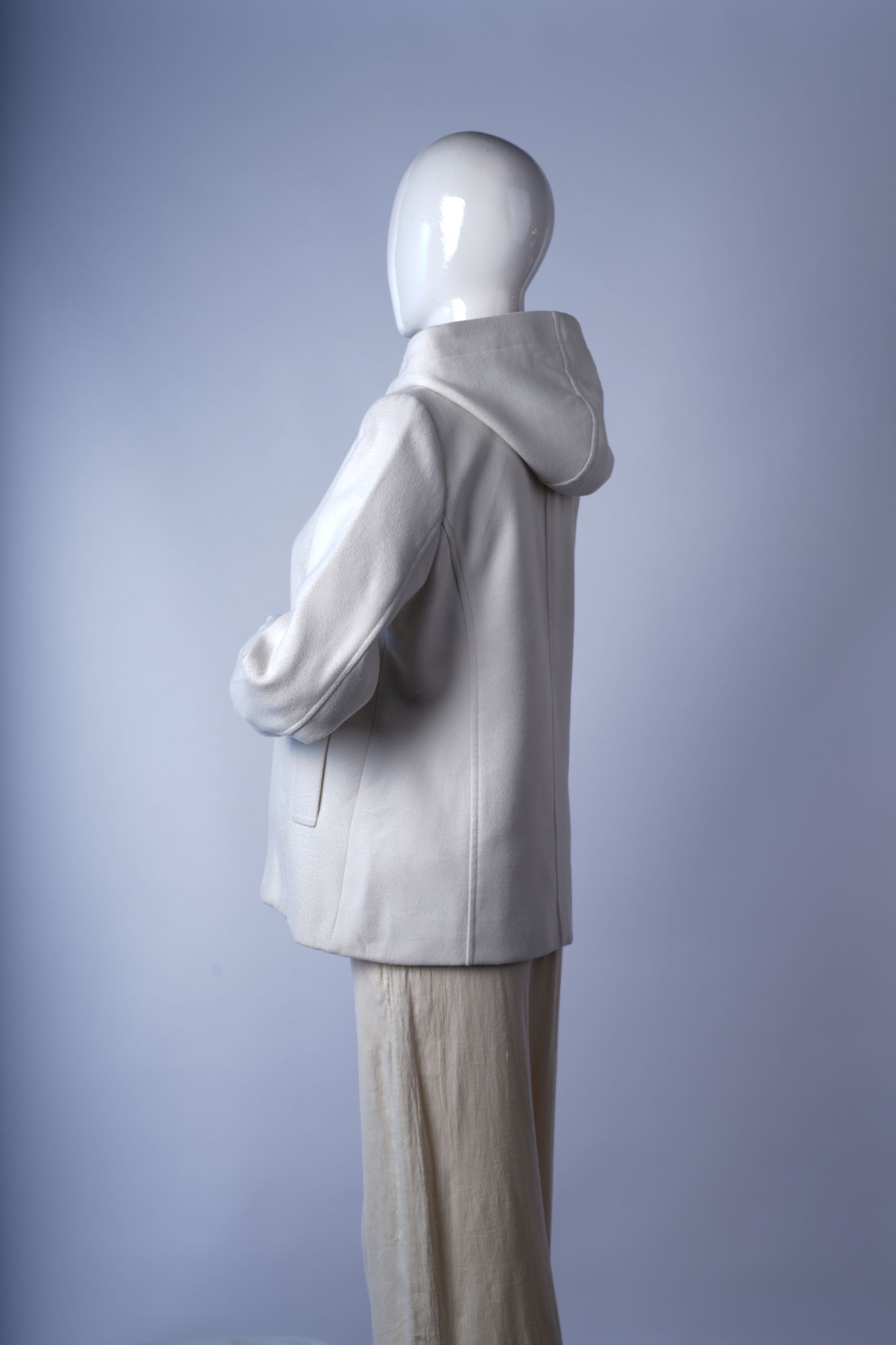 Soft wool-blend longline coat in ivory with sophisticated tailored details.