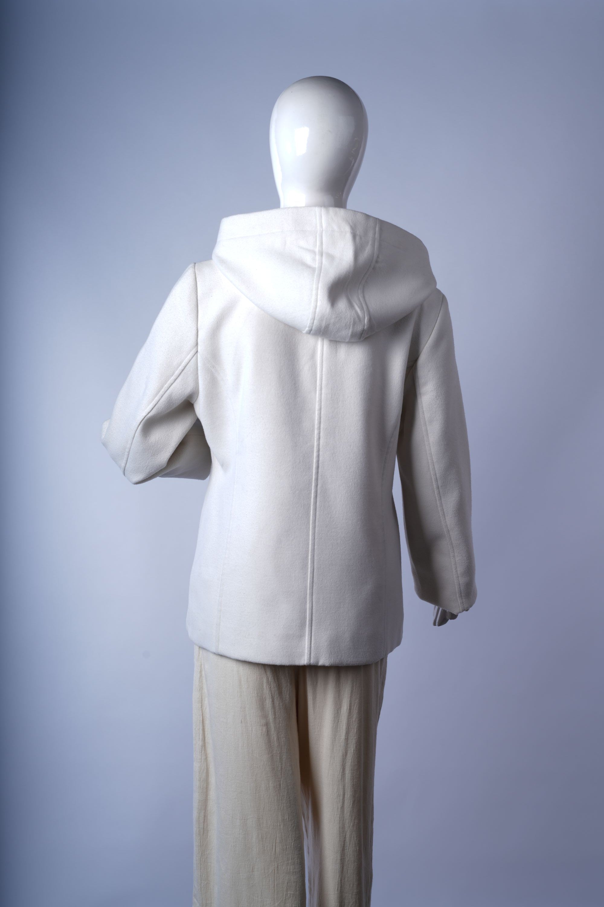 Stylish ivory overcoat with wide lapels and side pockets, perfect for polished winter looks.