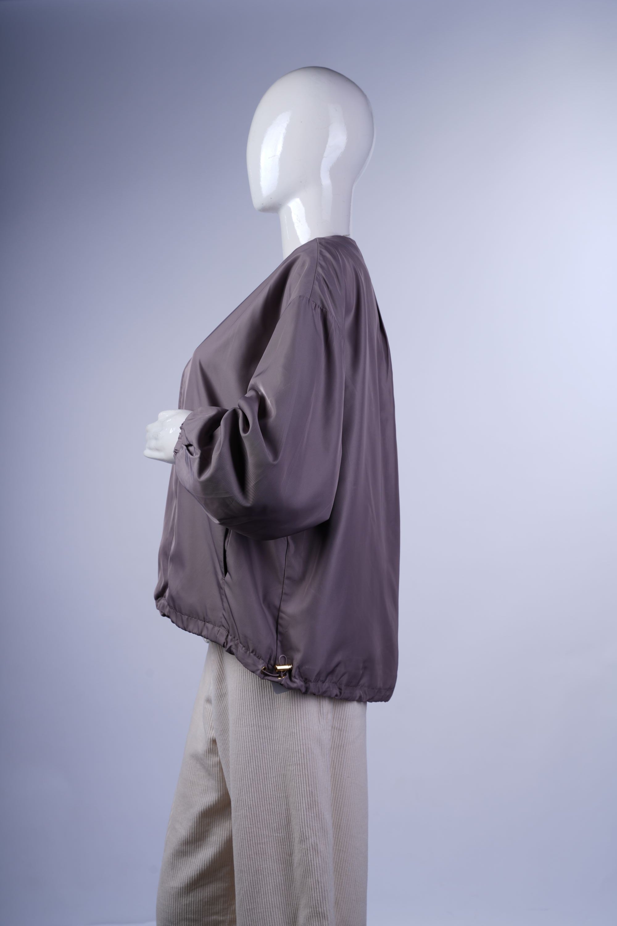 Minimalist spring jacket with elasticated cuffs and hem, full front zipper, and a modern, streamlined silhouette.
