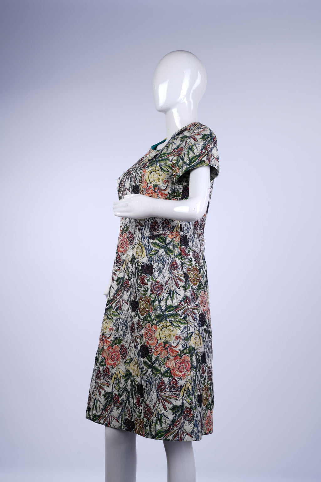 Casual knee-length dress featuring a bright floral pattern on a light cream base.