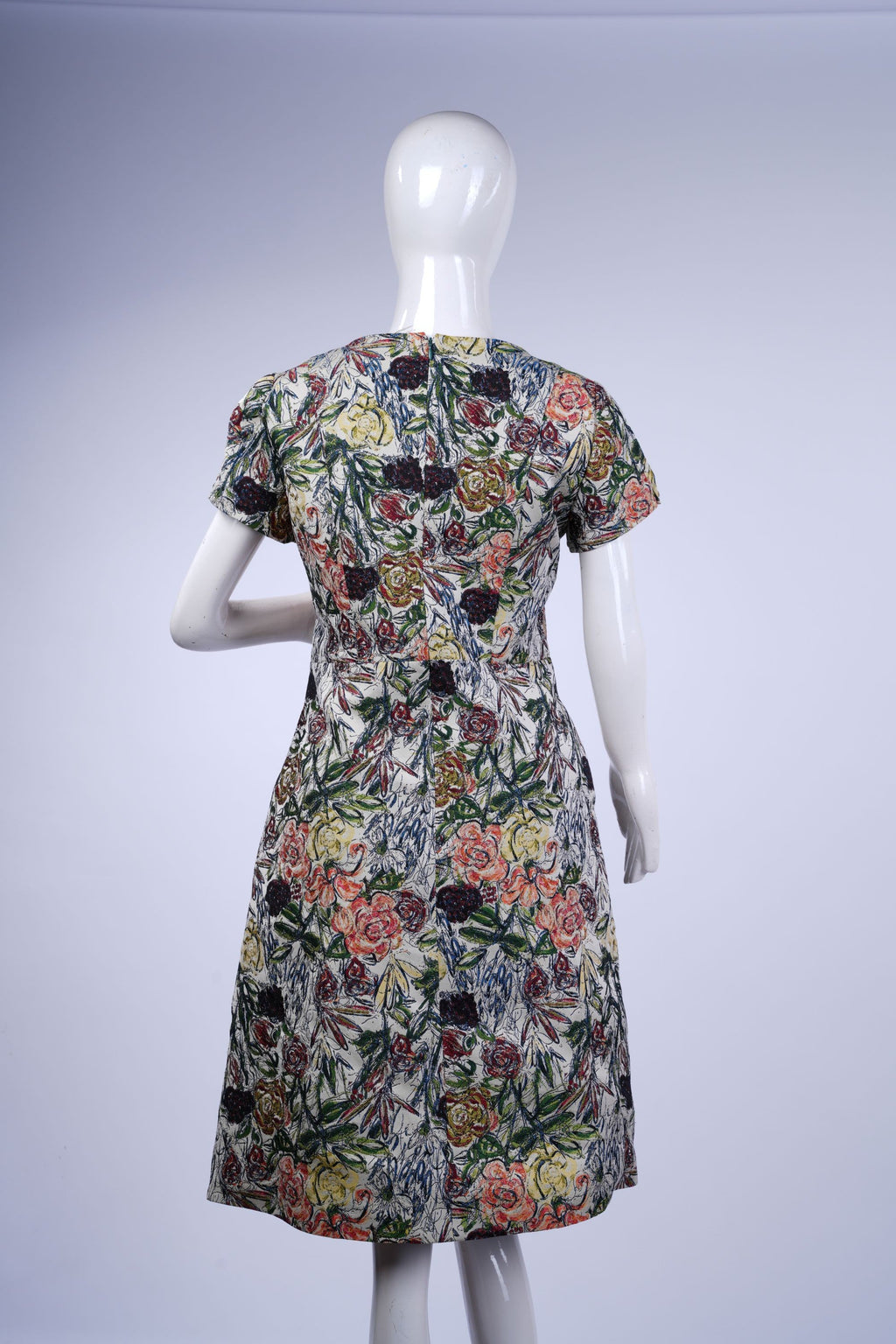 Light cream dress with colorful floral design, knee-length cut, perfect for daytime or warm-weather style.