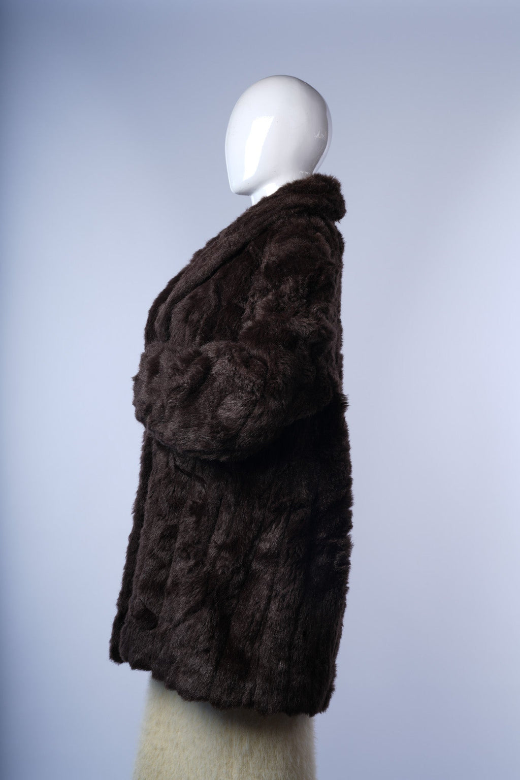 Vintage-inspired dark brown faux-fur coat with plush texture and relaxed silhouette.