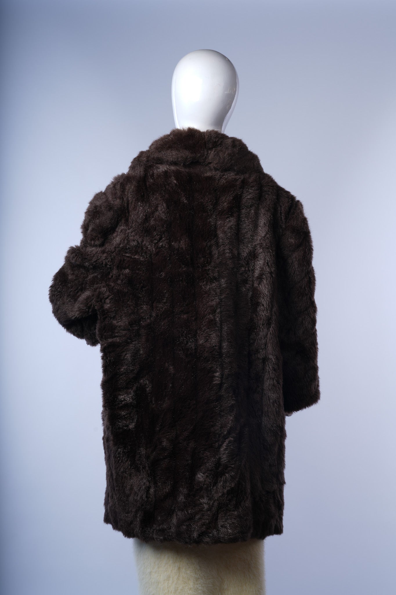 Stylish dark brown faux-fur jacket providing warmth and timeless sophistication.