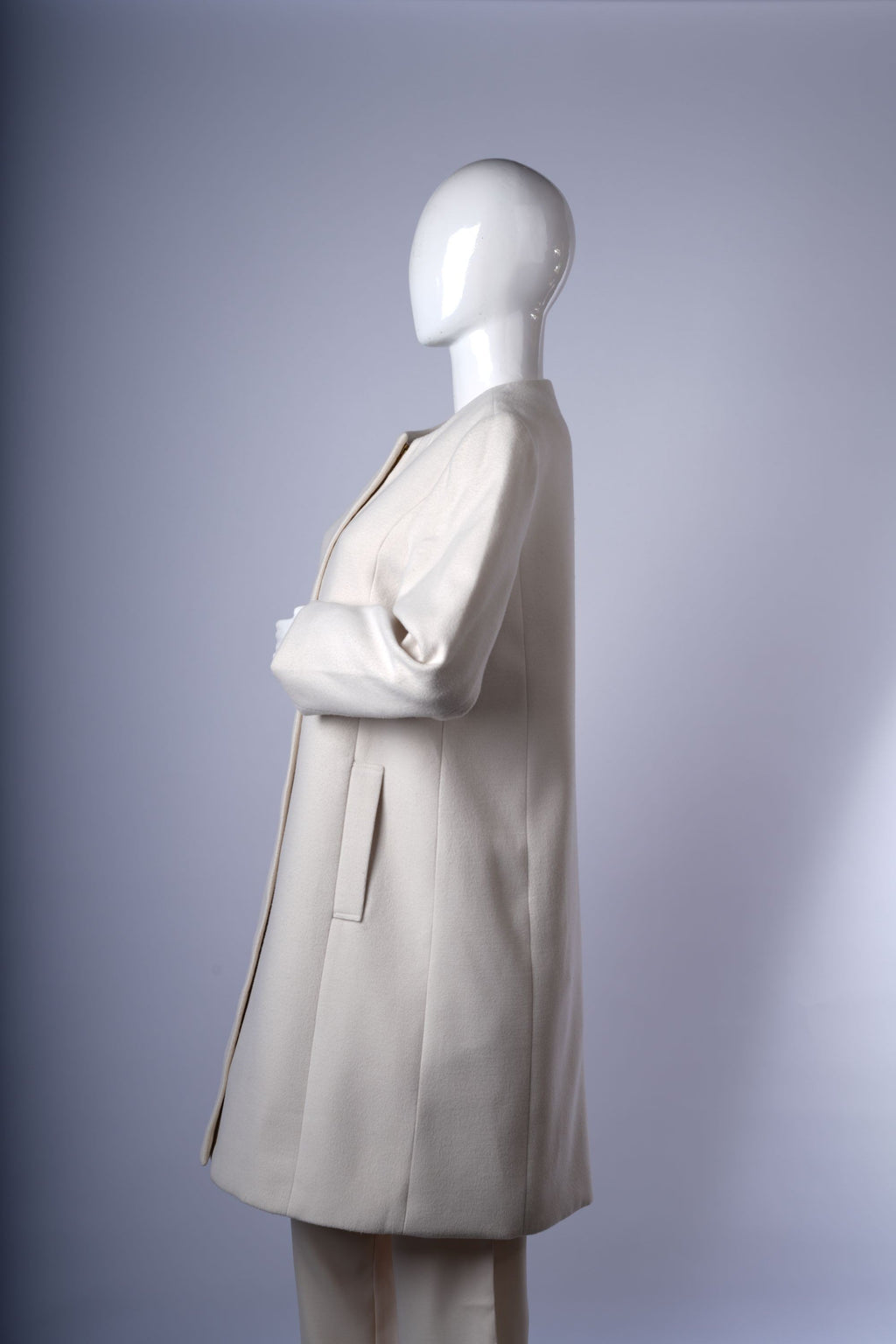 Chic longline off-white jacket featuring discreet pockets and sleek zipper closure.