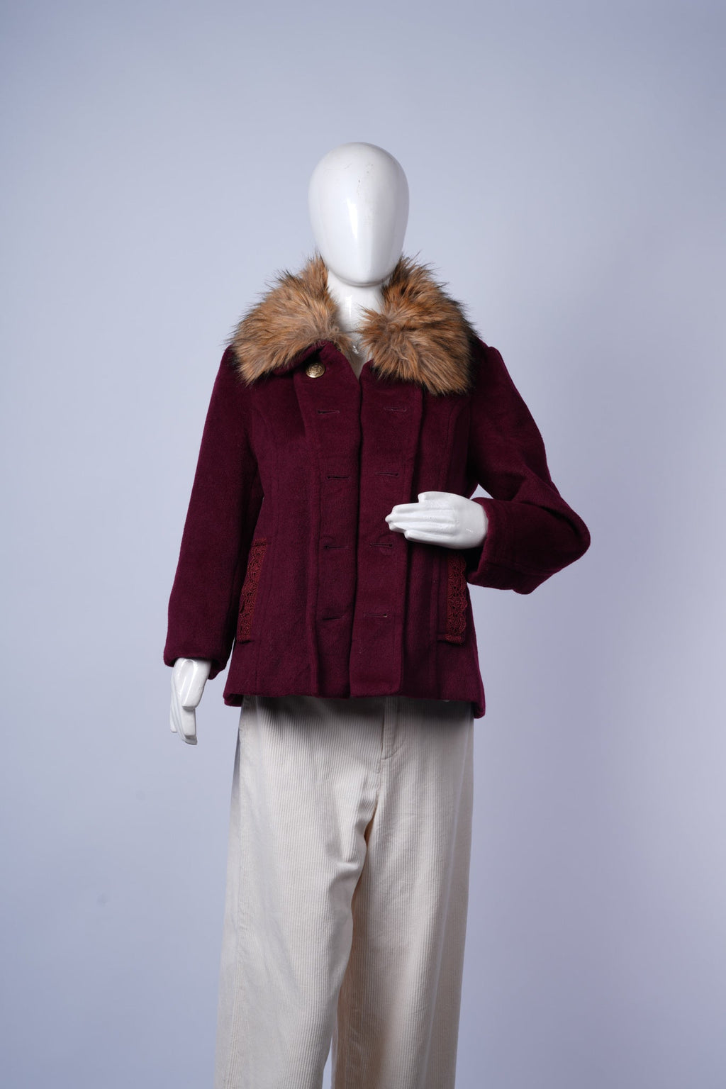 women's maroon winter coat featuring stylish fur collar and decorative lace pockets.