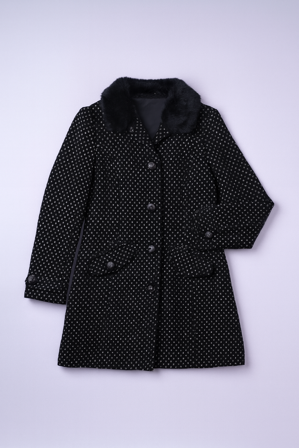 Black leather-style coat with dark faux fur collar and bold polka-dot lining.