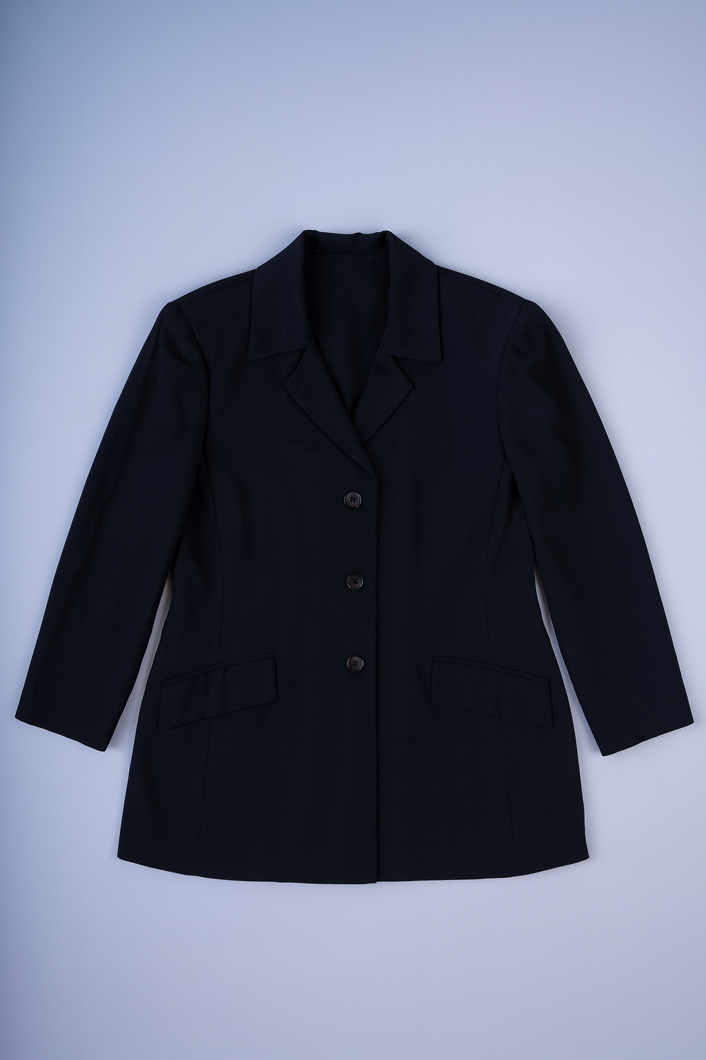 Structured black coat with classic lapels, three-button closure, and flap pockets.