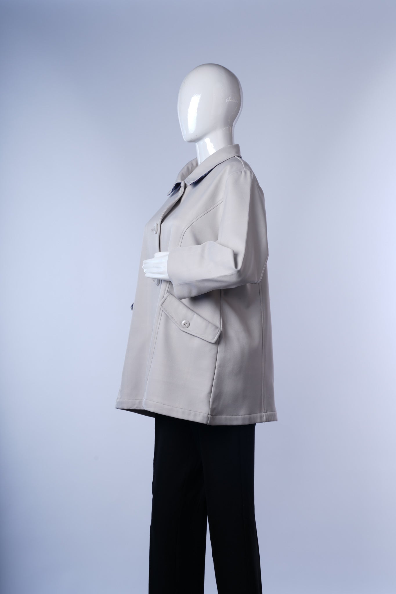 Elegant long coat with classic lapels, button-front closure, and practical pockets.