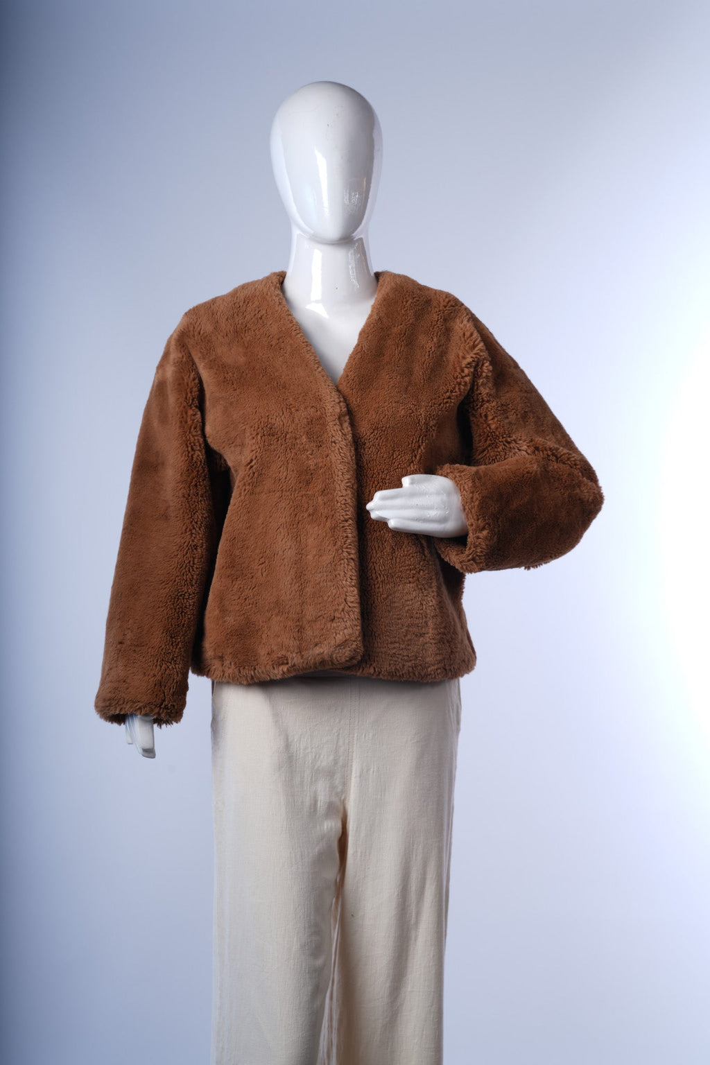 Stylish camel-colored cropped faux fur jacket, perfect for layering.