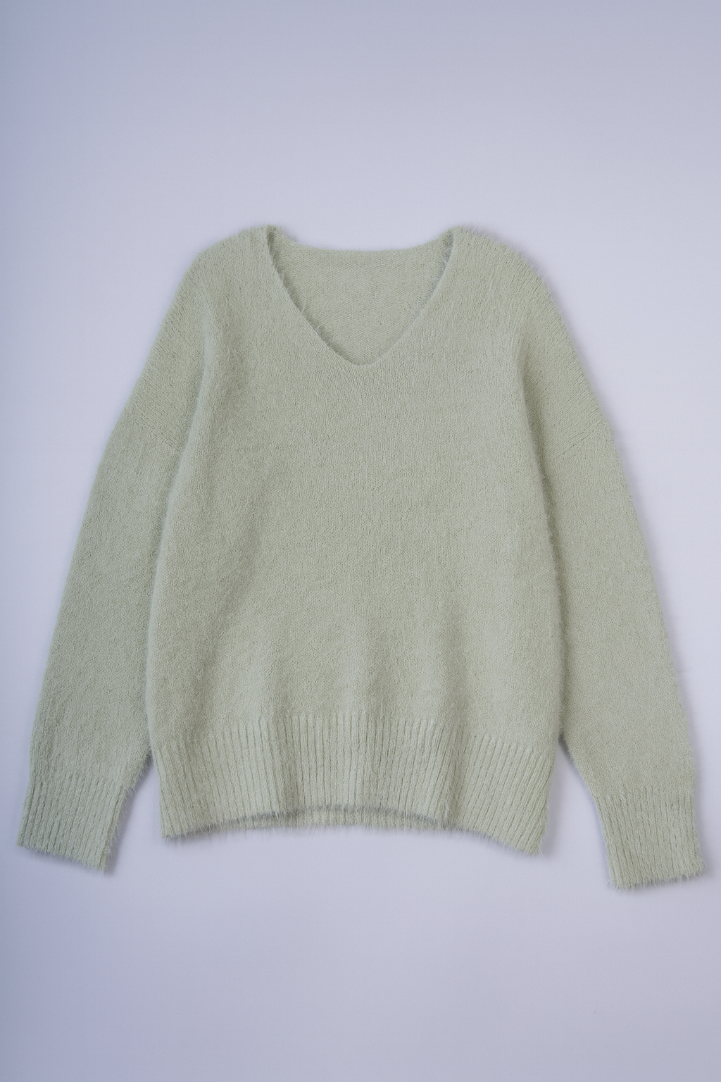 women's oversized fuzzy knit sweater with V-neck and relaxed fit.