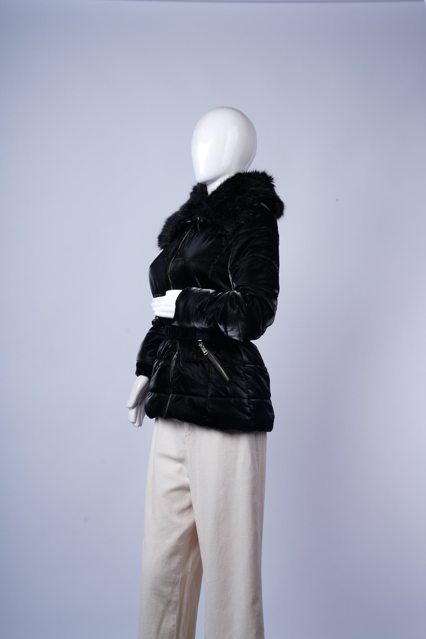 Flattering black winter jacket featuring faux fur trim and cinched waist.