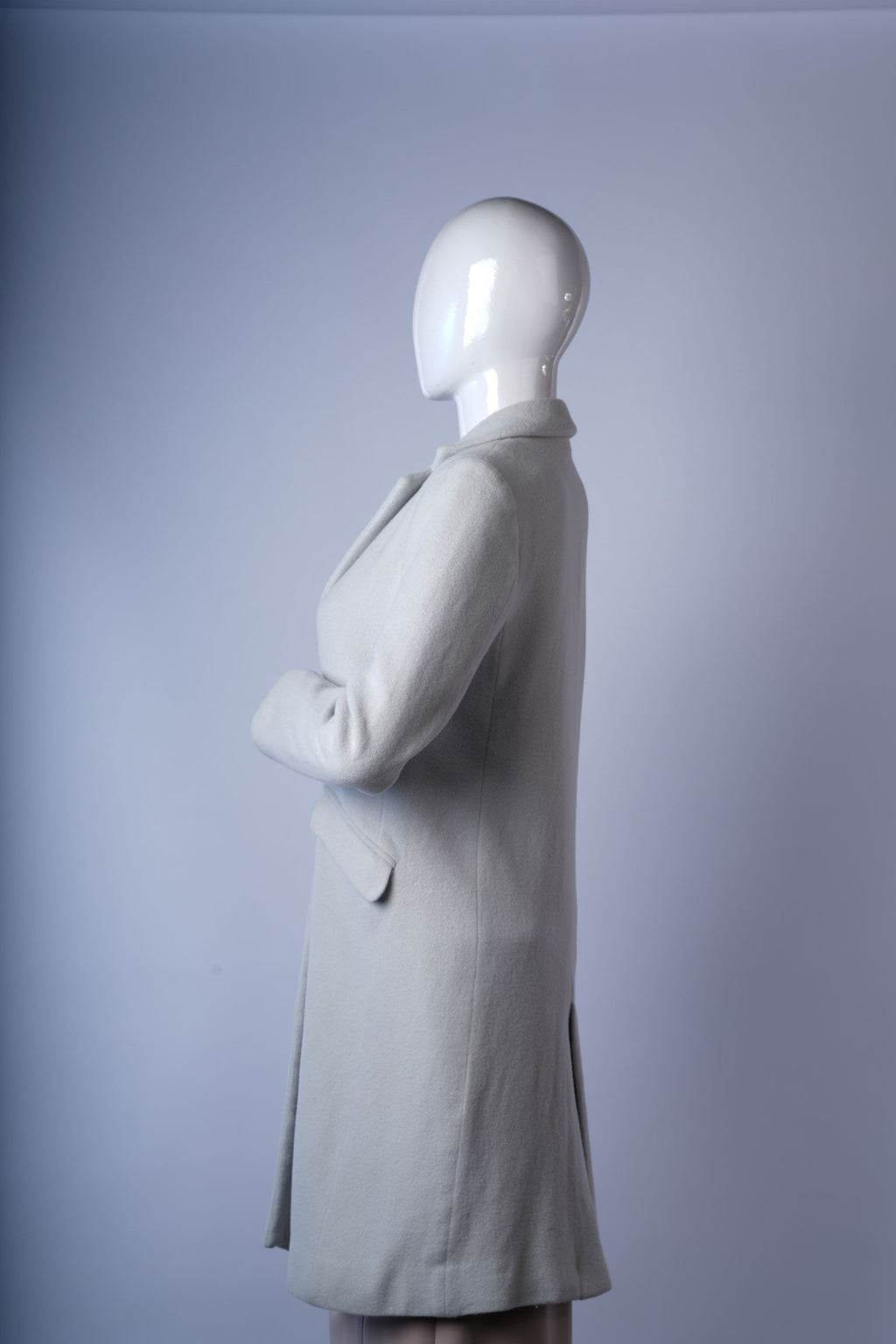 Luxurious light gray coat featuring tailored design and classic flap pockets.