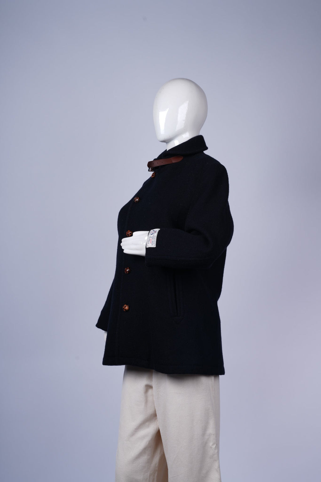 Classic double-breasted navy coat with leather-trimmed collar and functional pockets.