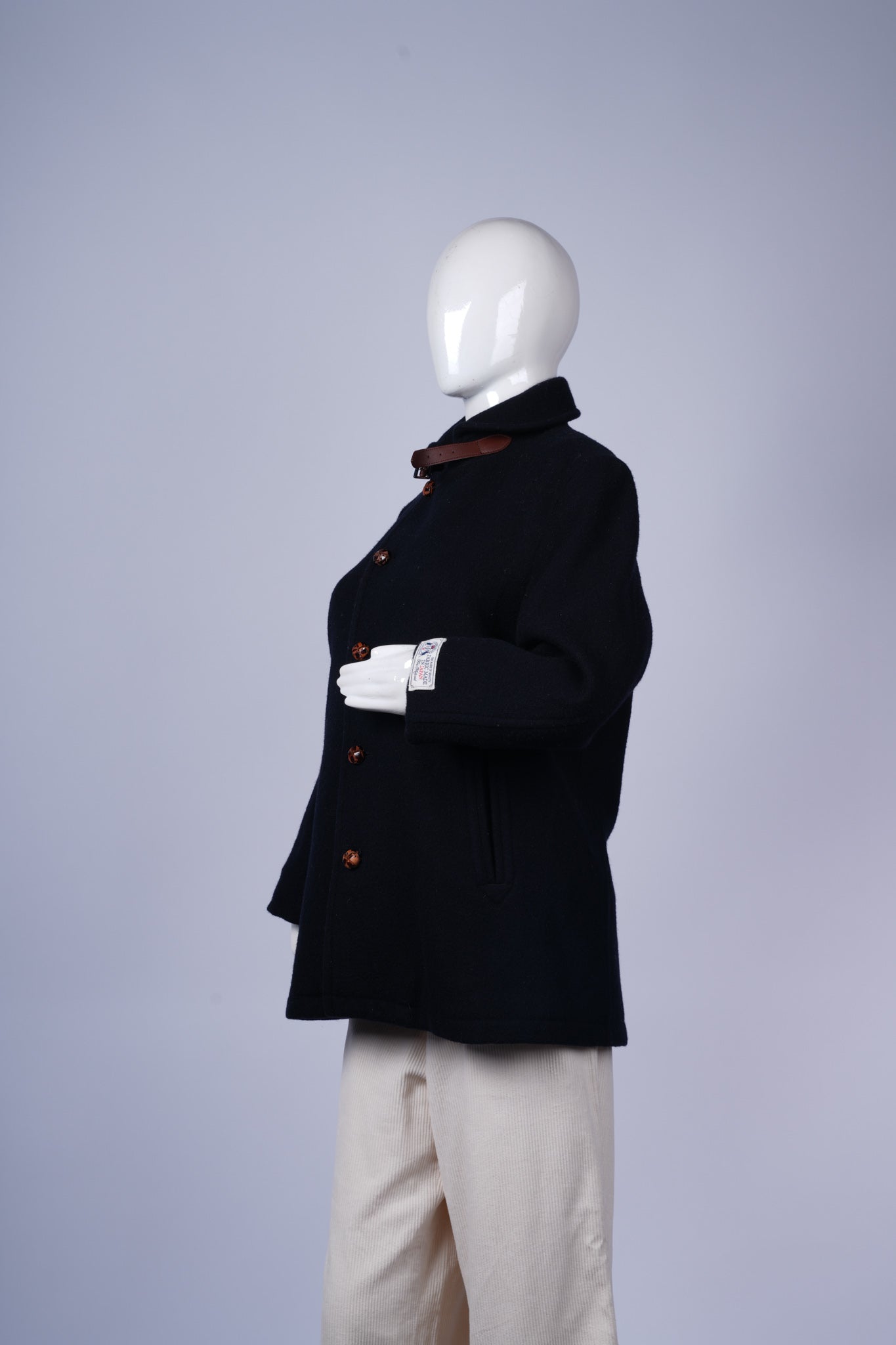 Classic double-breasted navy coat with leather-trimmed collar and functional pockets.