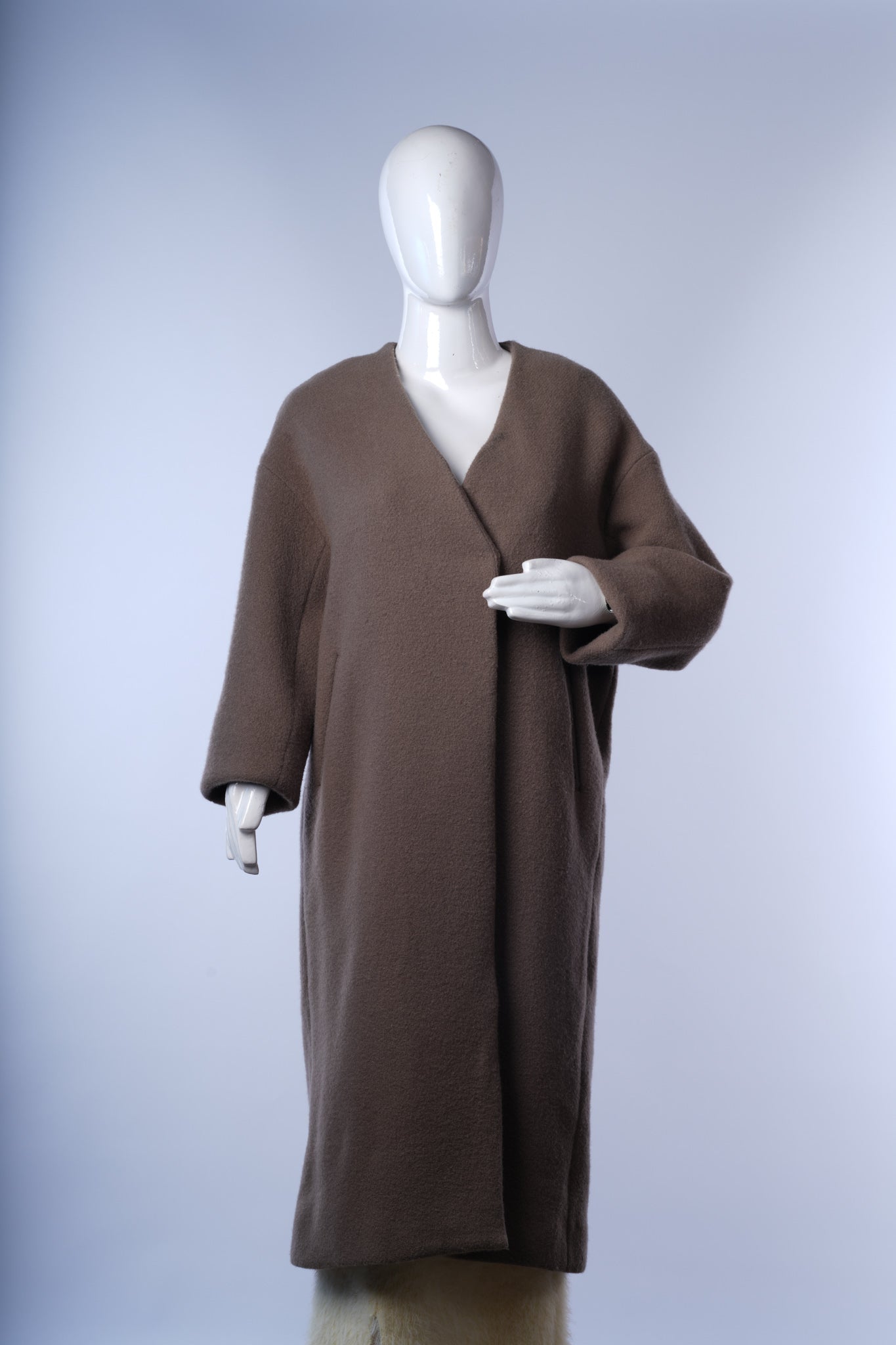Sleek neutral wool coat for women with modern collarless design and gold accents
