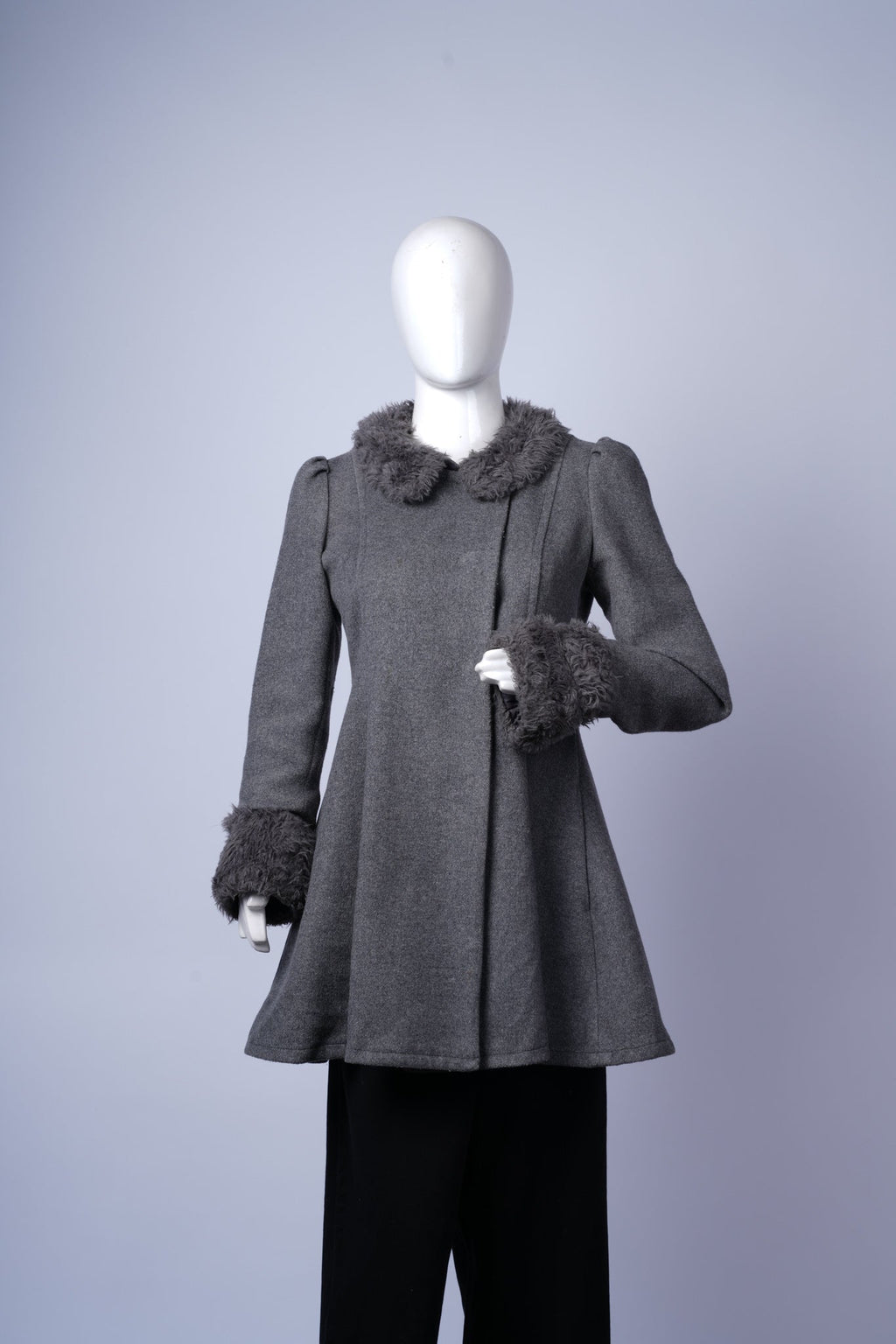 women's stylish coat featuring asymmetrical buttons and cozy fur collar and cuffs.
