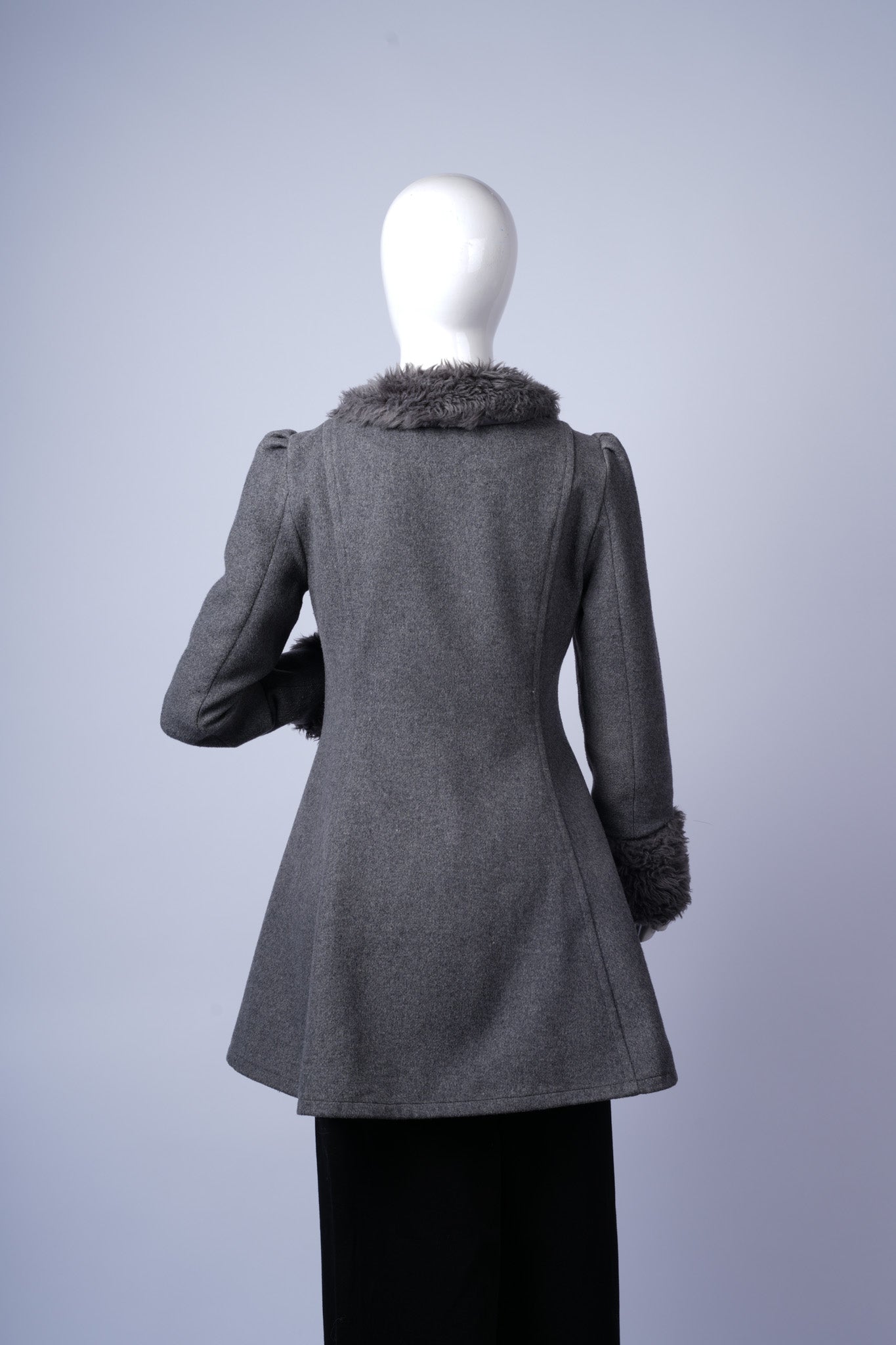 Elegant winter coat with puffed sleeves and fur accents, combining warmth and fashion.